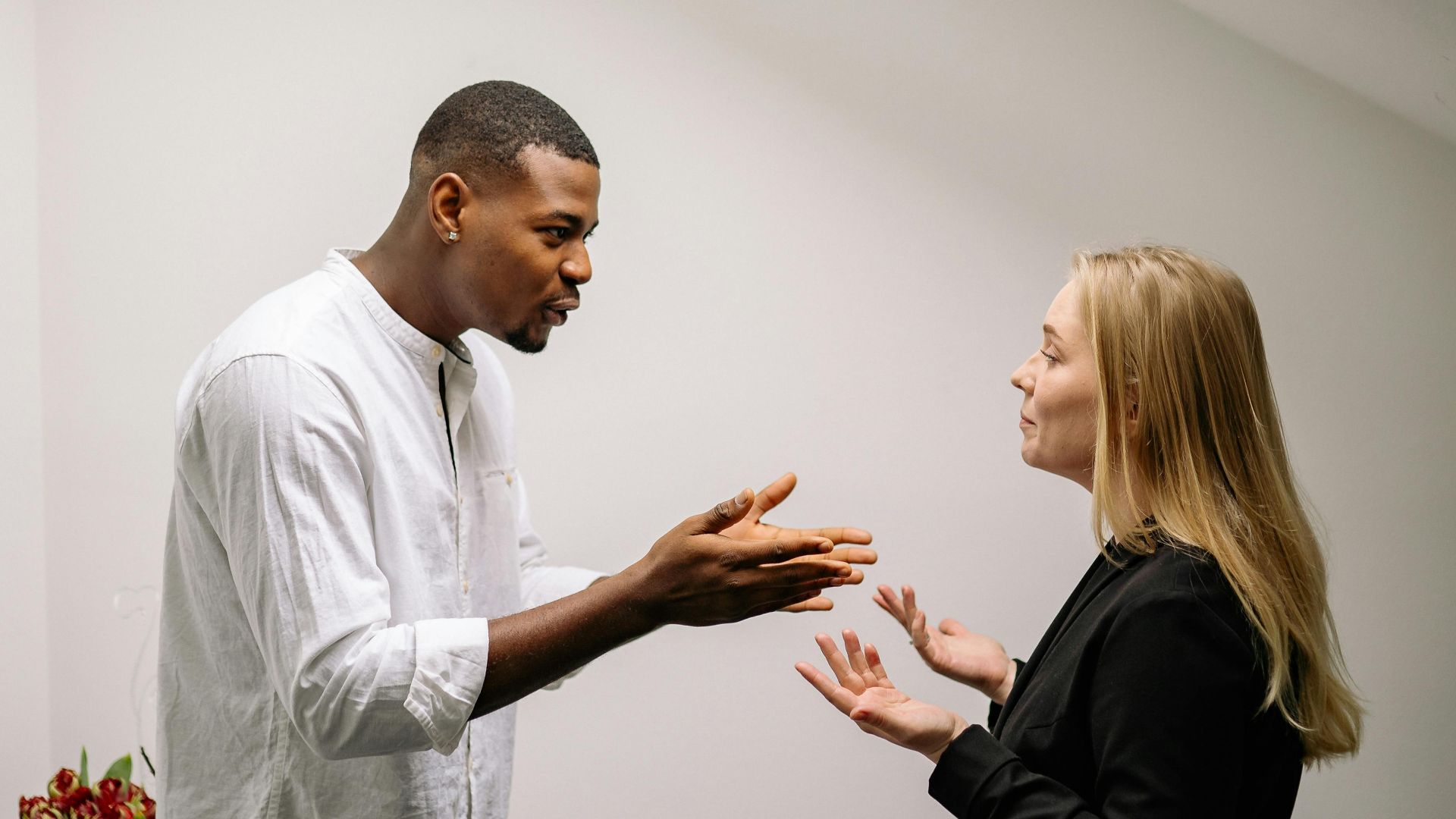 A serious discussion between two colleagues in an office setting, highlighting workplace conflict.