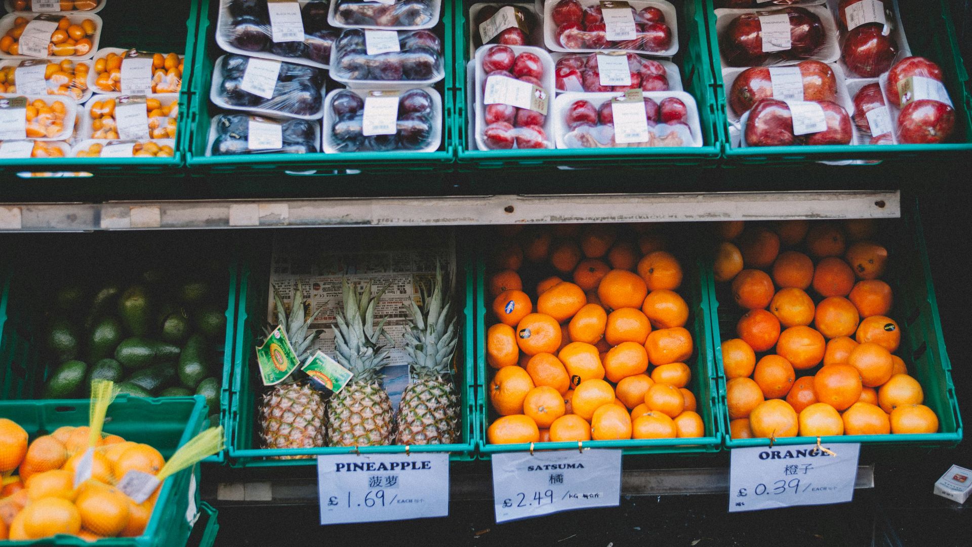 Colorful assortment of fresh fruits displayed in a local market stall with price tags.