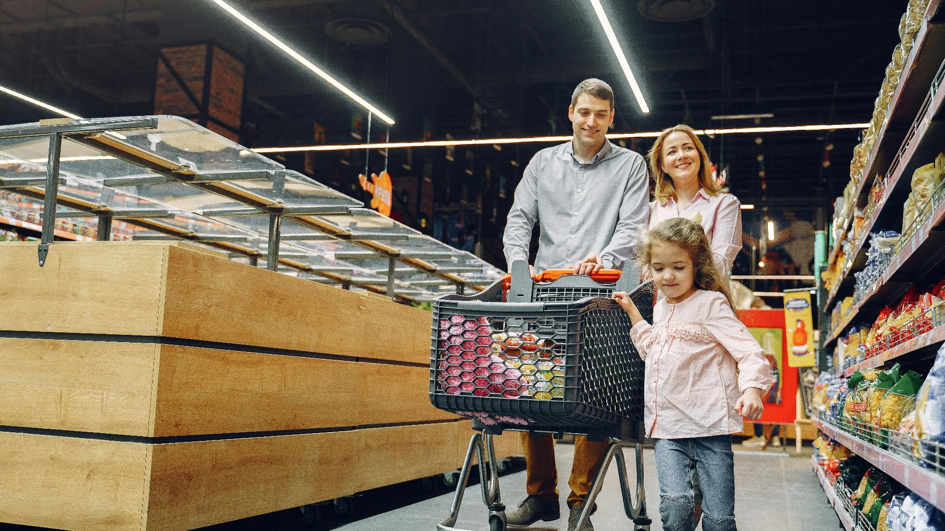 A joyful family shopping together in a supermarket aisle, enjoying their day.