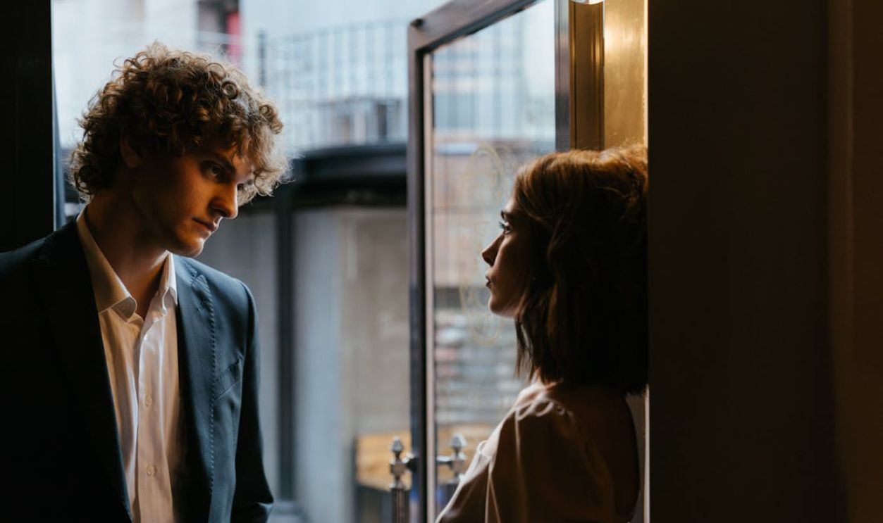 Woman in Brown Coat Looking Out the Window