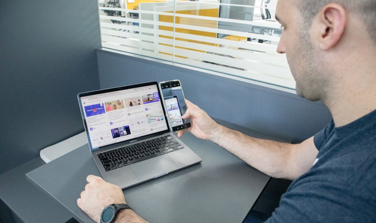 Man Taking Pictures of Laptop Screen