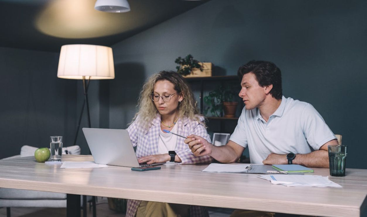 Man and Woman Sitting at Table Working Together