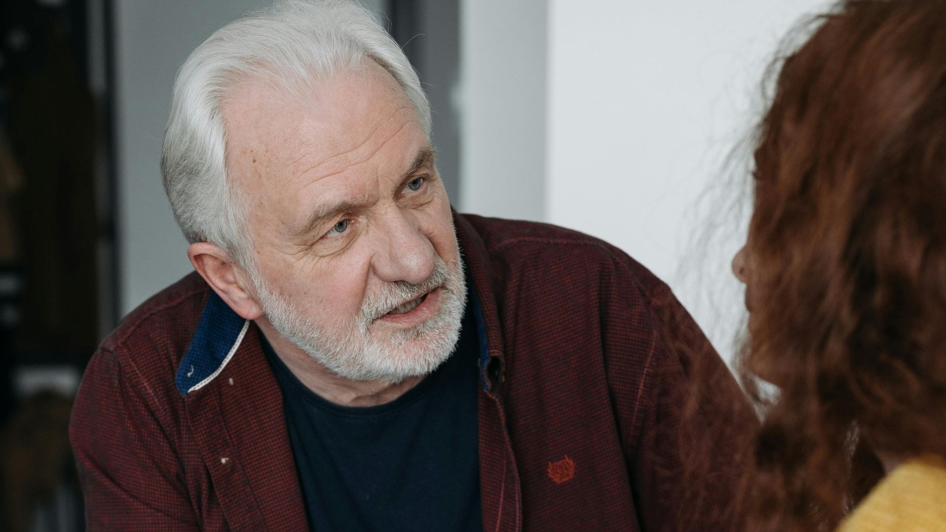 An elderly man and young woman discussing something important indoors.