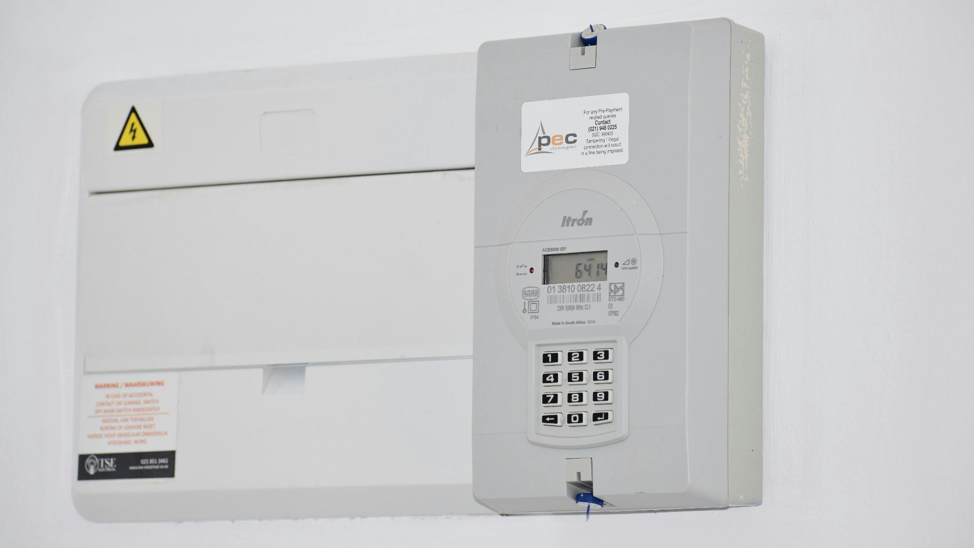 Electrical meter and fuse box on a white wall in Cape Town, South Africa, for energy monitoring or billing.