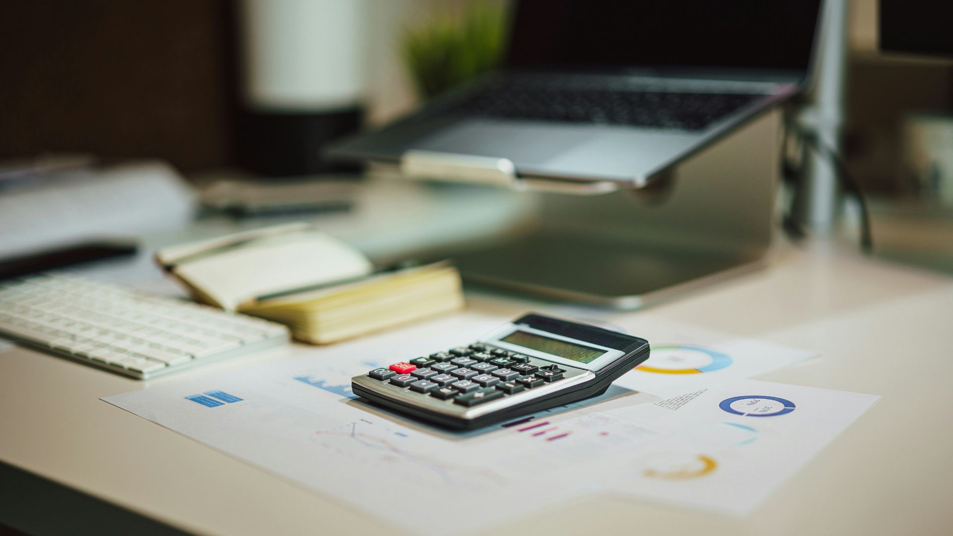 a calculator sitting on top of a table next to a laptop