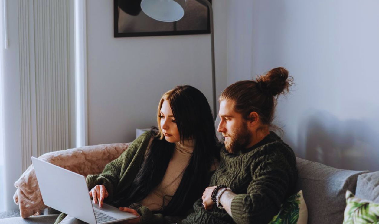 Couple surfing internet on laptop in living room