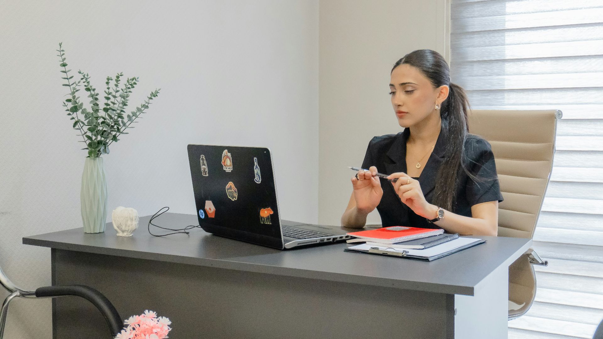 Woman working on a laptop at a desk.