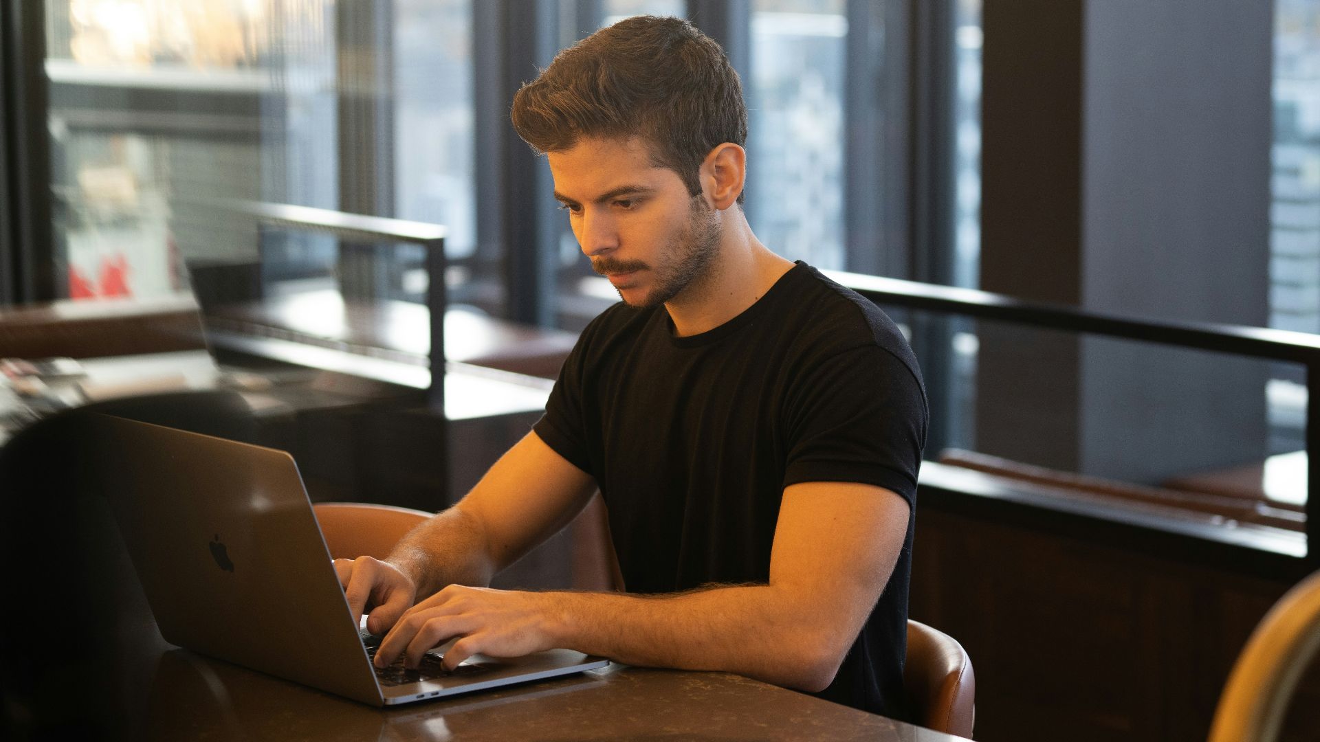 man in black crew neck t-shirt using macbook