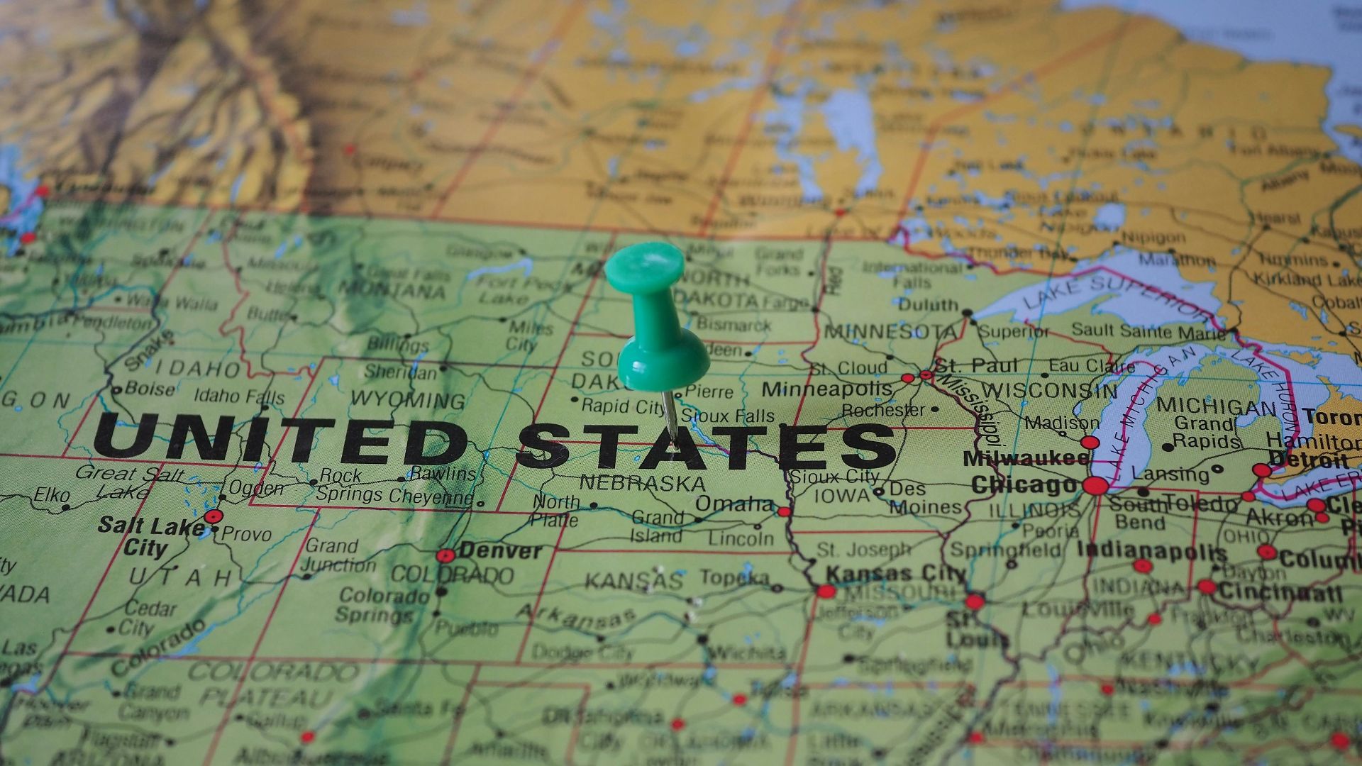 High-angle view of a map featuring the United States with a green pin indicating a specific location.