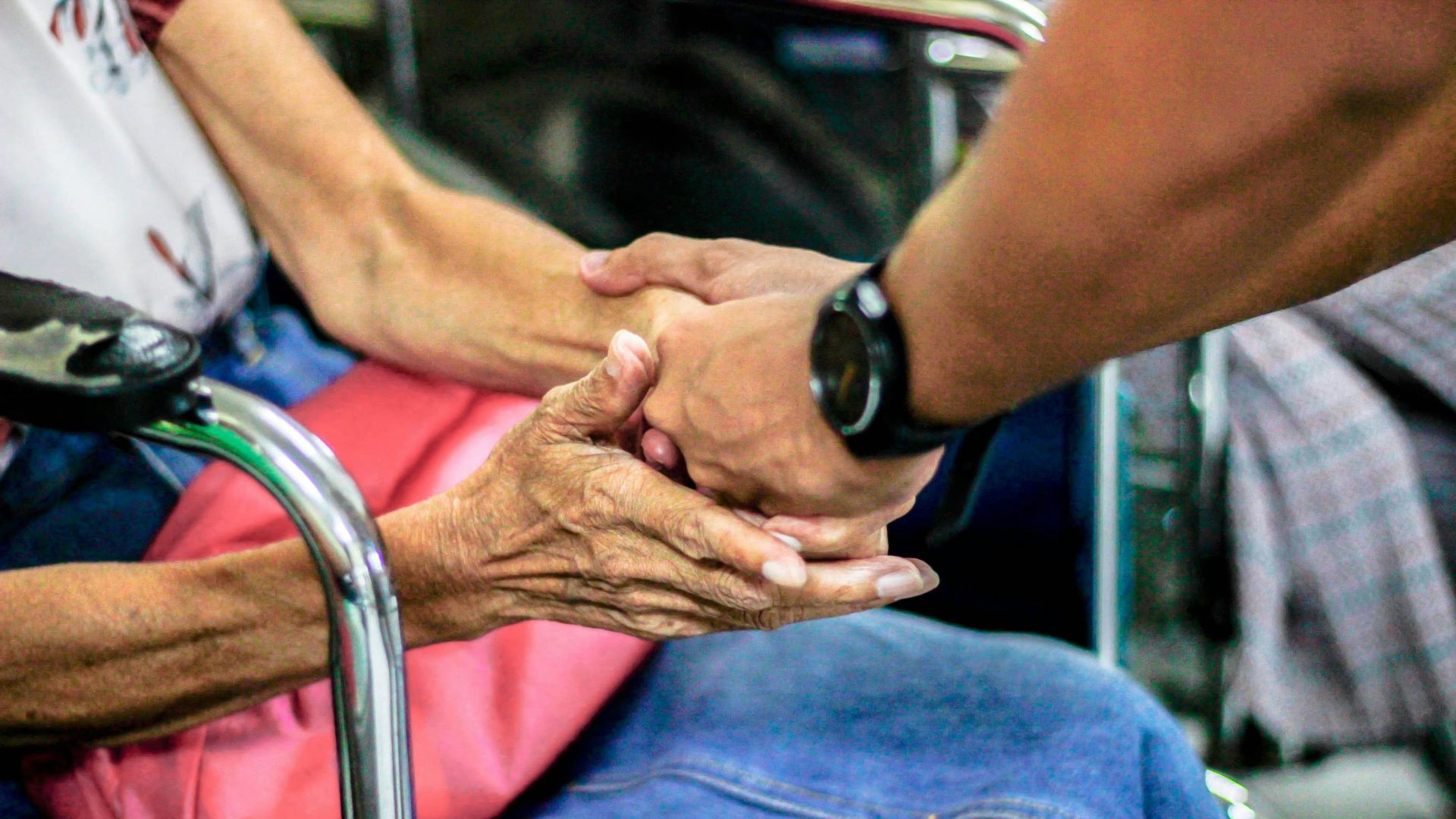 man holding hand with woman on chair