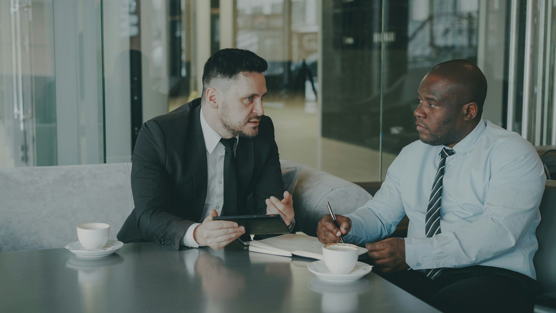 Two businessmen discussing work over coffee.