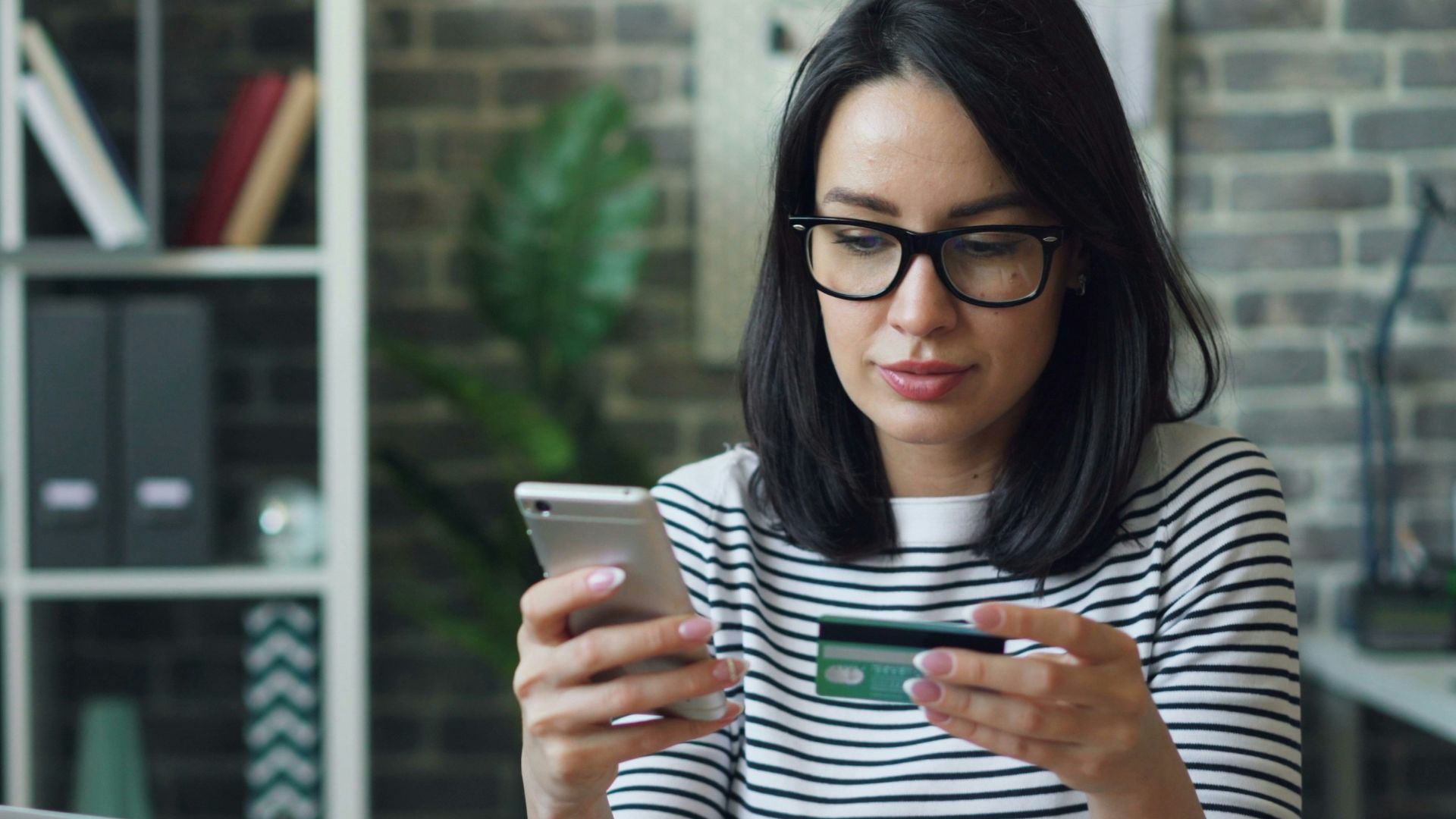 a woman sitting at a table looking at her cell phone