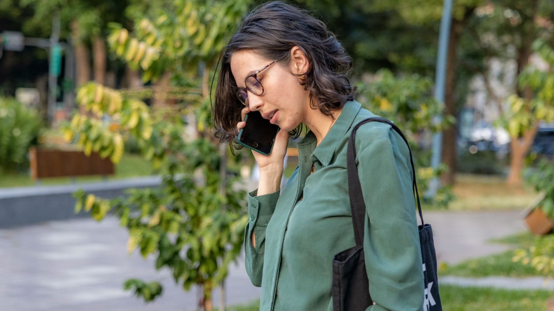 a woman talking on a cell phone in a park