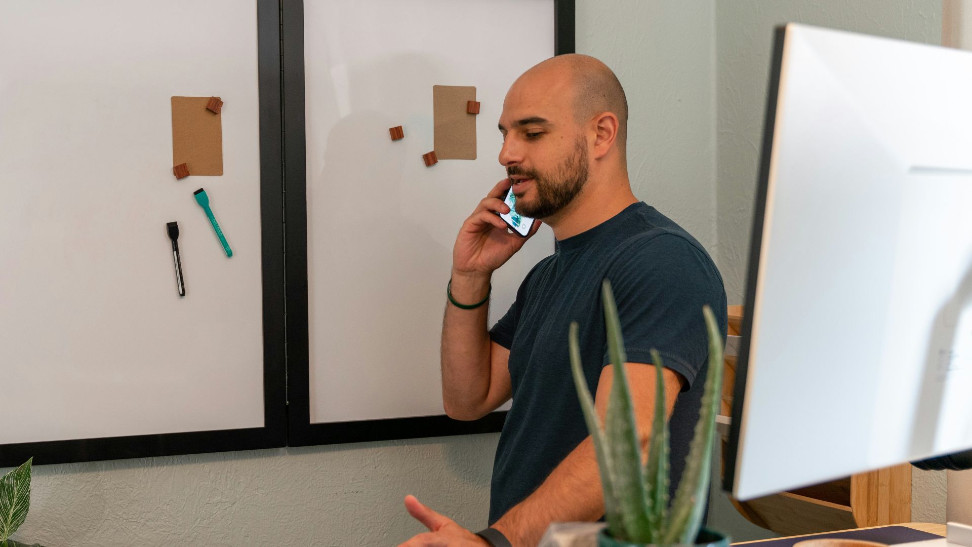 a man talking on a cell phone in front of a cake