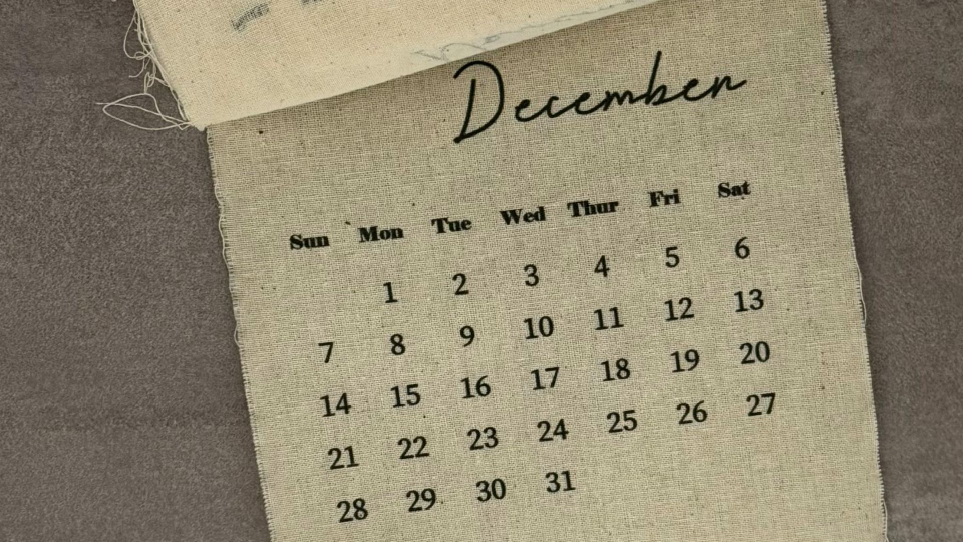 A vintage-style hanging calendar page displaying December dates, ideal for home decor.