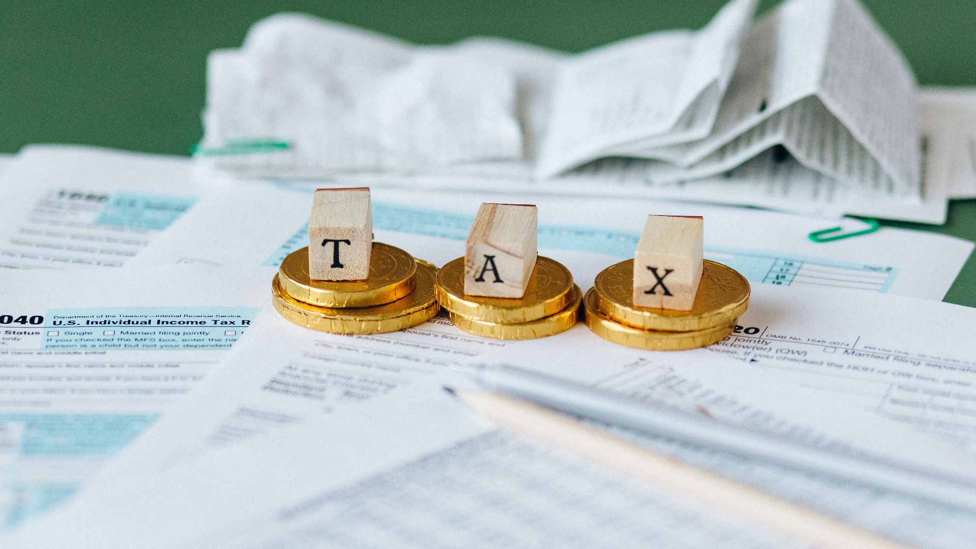 Close-up of tax forms, receipts, and coins symbolizing financial accounting and taxes.