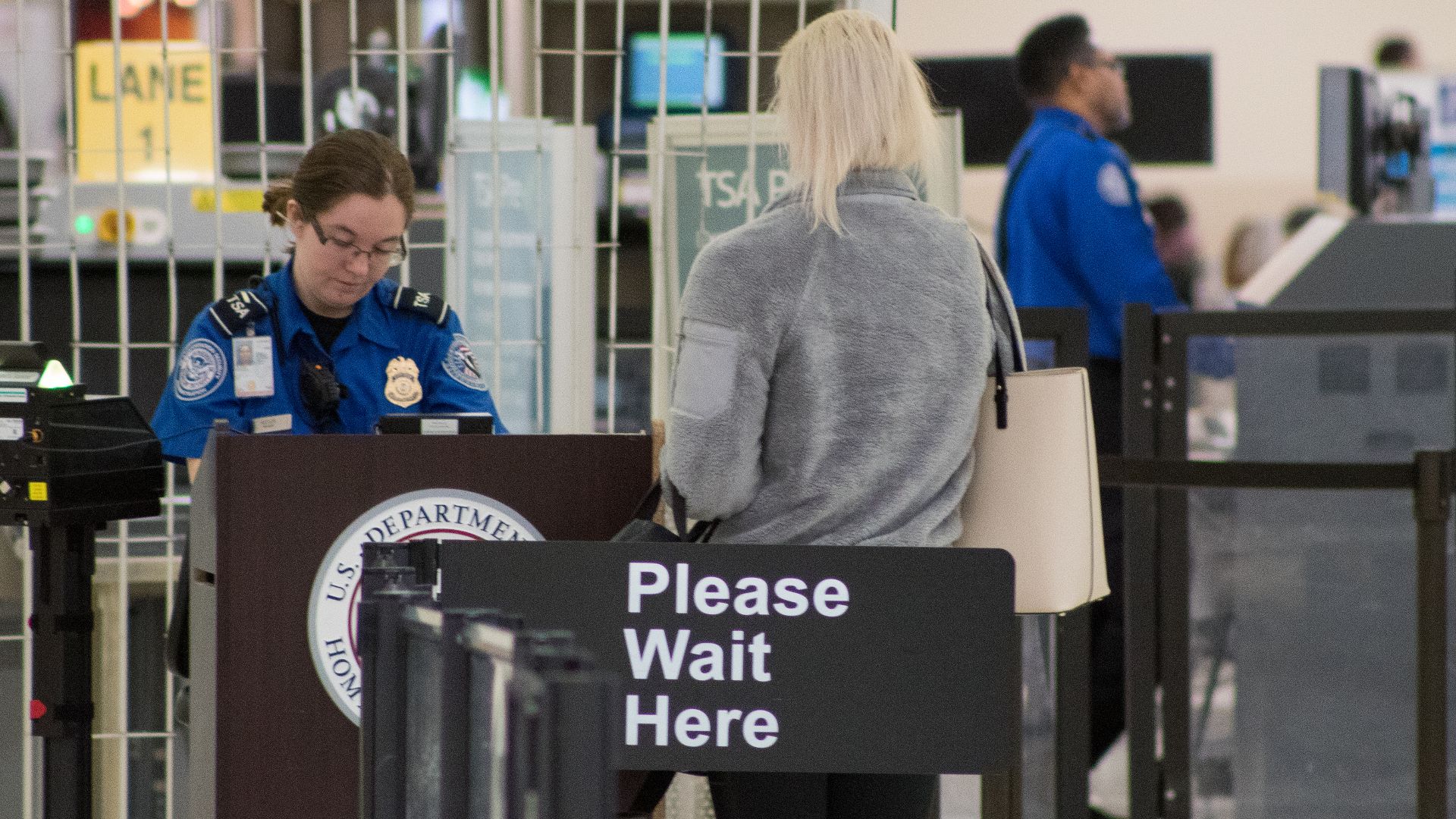 A Transportation Security Administration agent at a checkpoint verifying passenger identification, John Glenn Columbus International Airport
