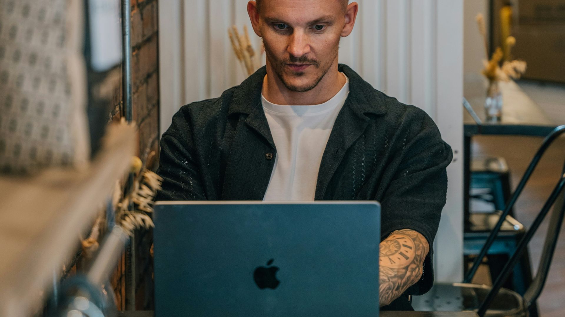 A man sitting at a table using a laptop computer