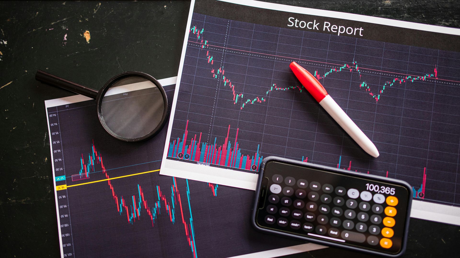 Stock report with charts, calculator, and magnifying glass for financial analysis.
