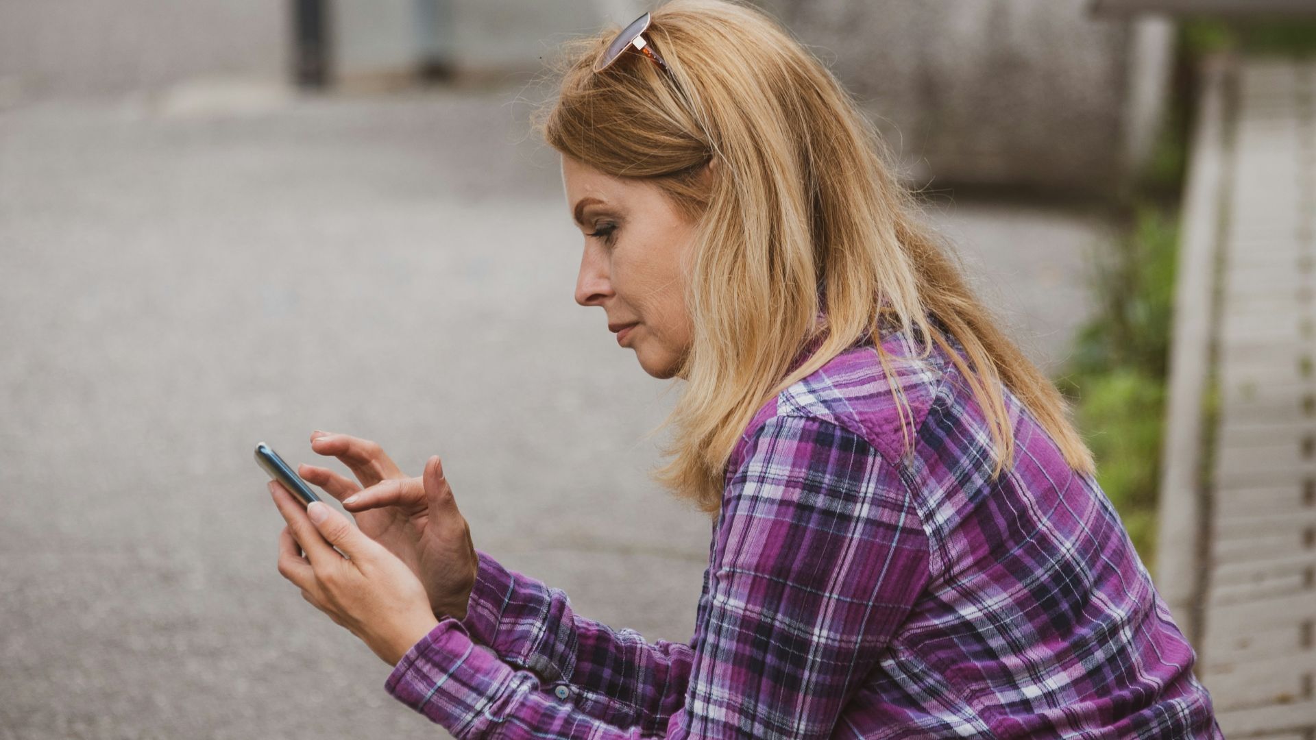 a woman sitting on the ground looking at her cell phone