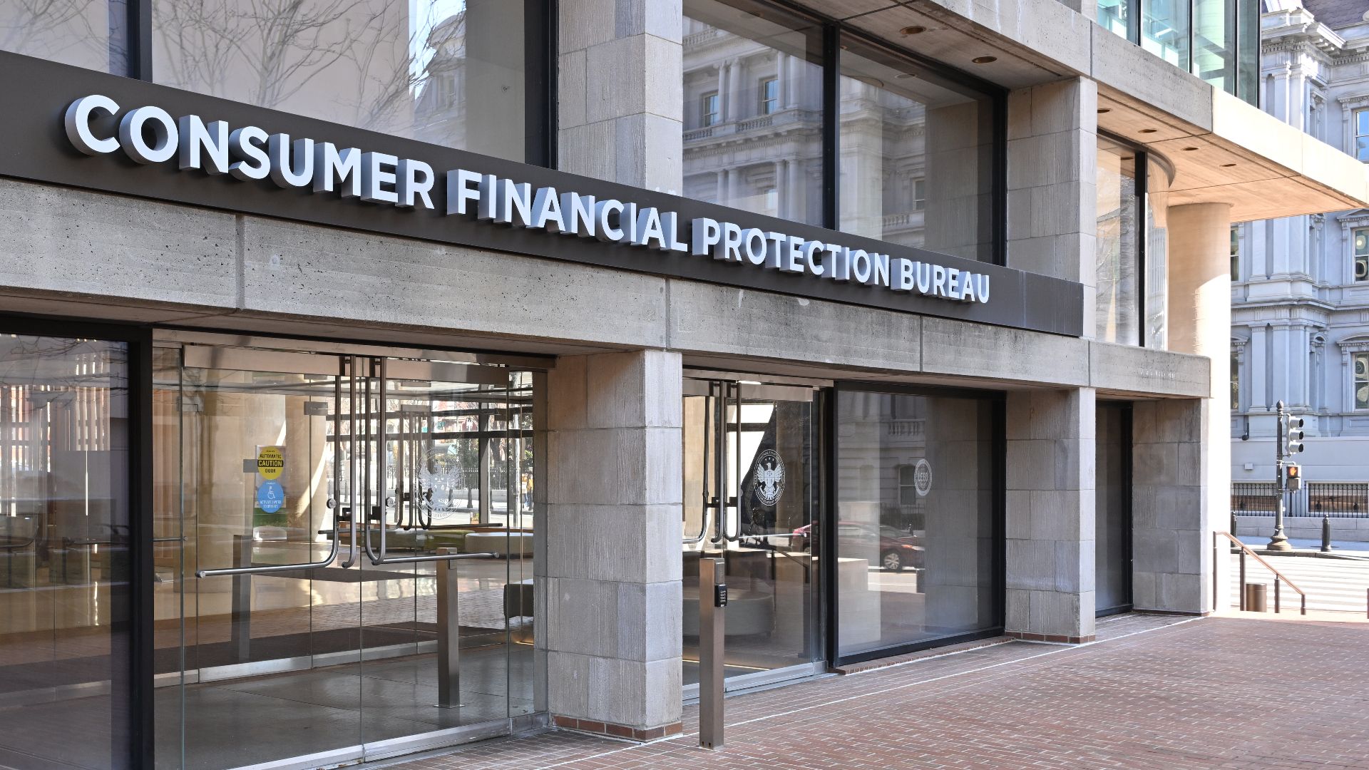 The entrance to the Consumer Financial Protection Bureau headquarters with the bureau's name above it. 1700 G Street NW, Washington, DC 20552.