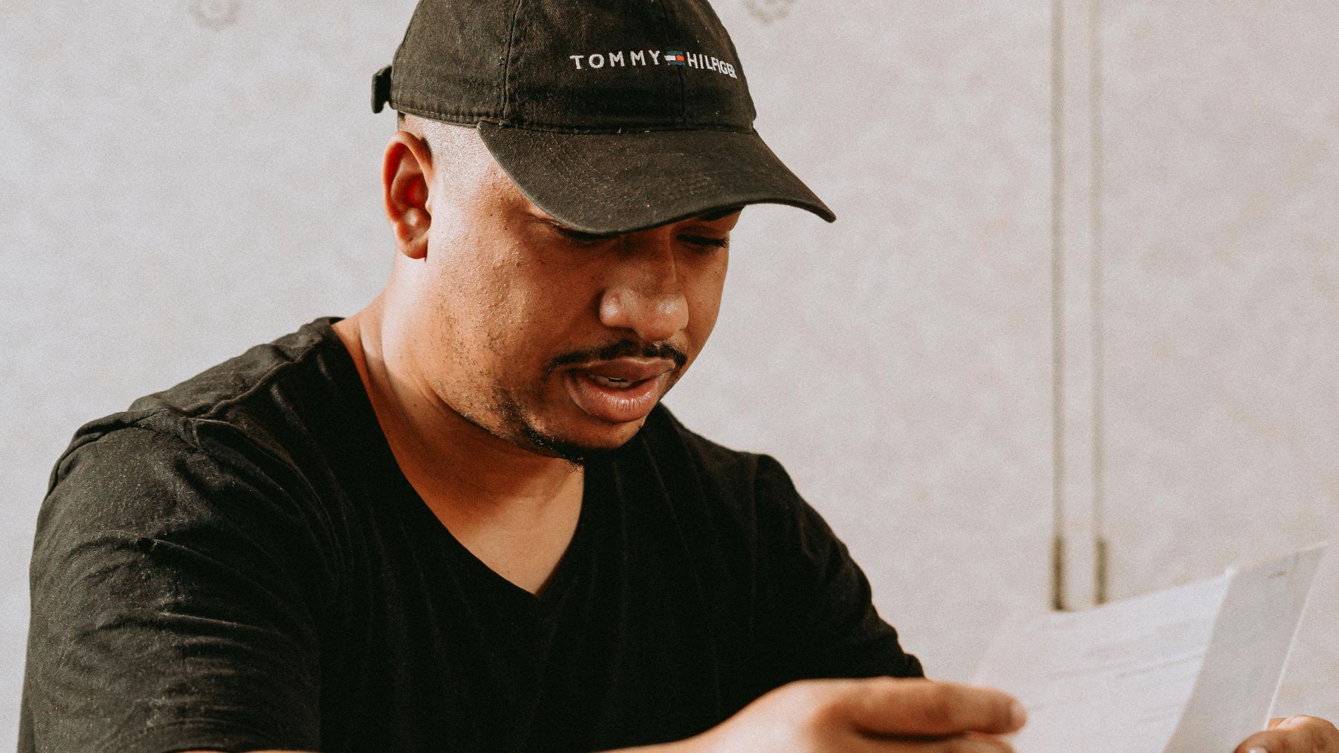 Adult man sitting at home table, focused on reviewing important documents.