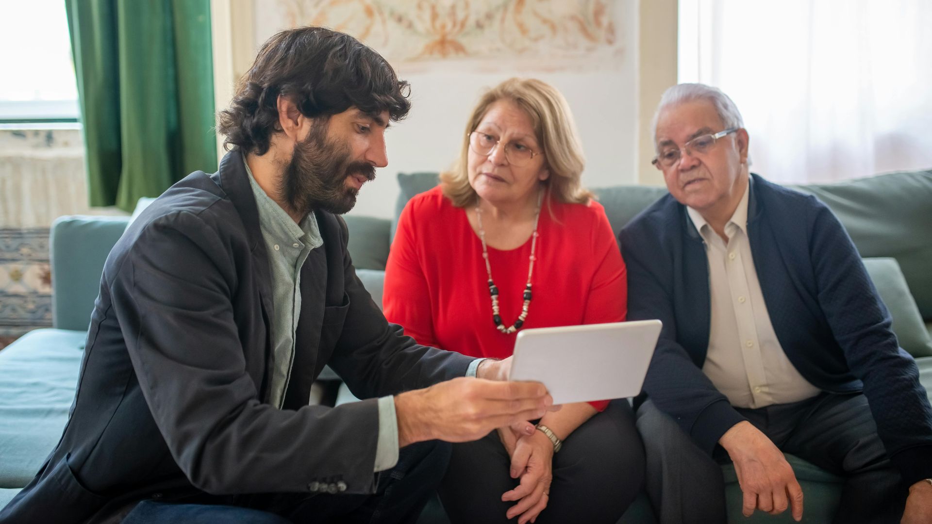A financial advisor discussing investment options with an elderly couple in a cozy living room.