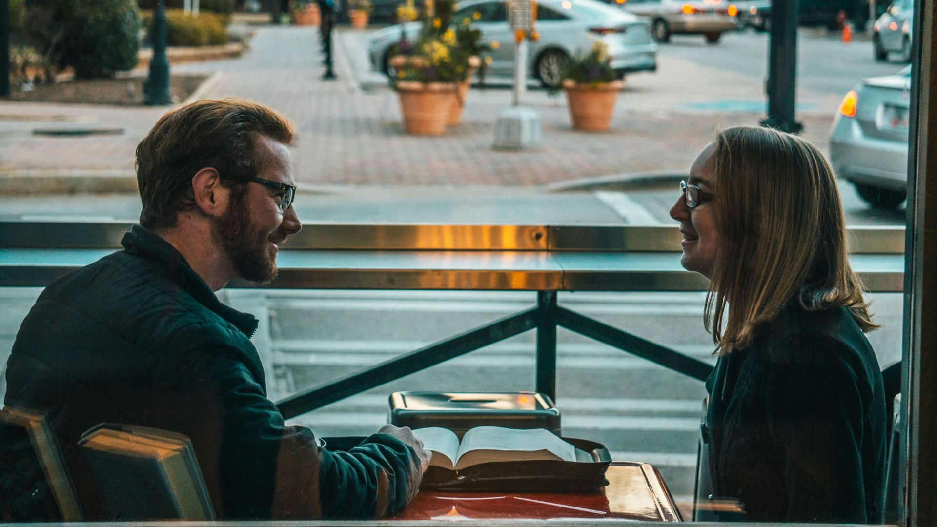 man and woman sitting while talking during daytime