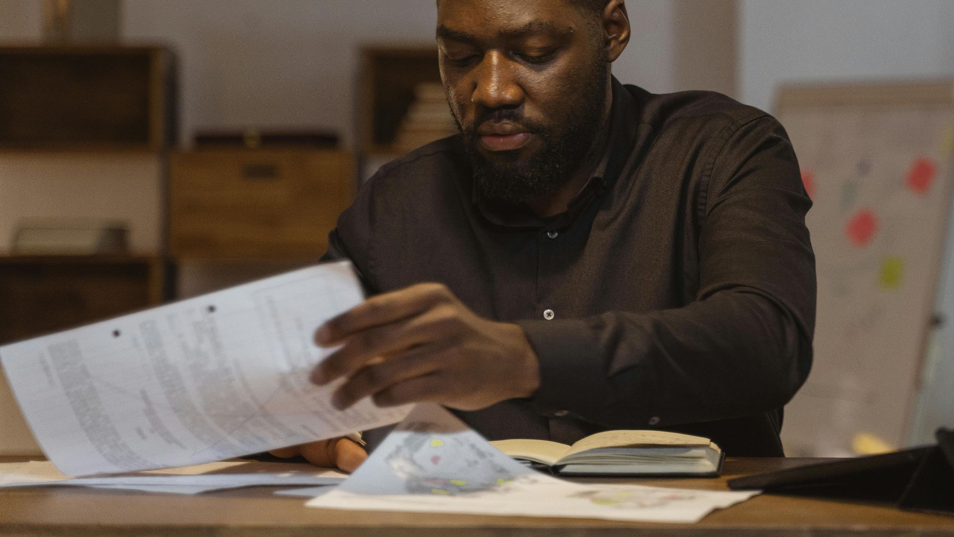 A serious businessman reviews important papers in a modern office setting.