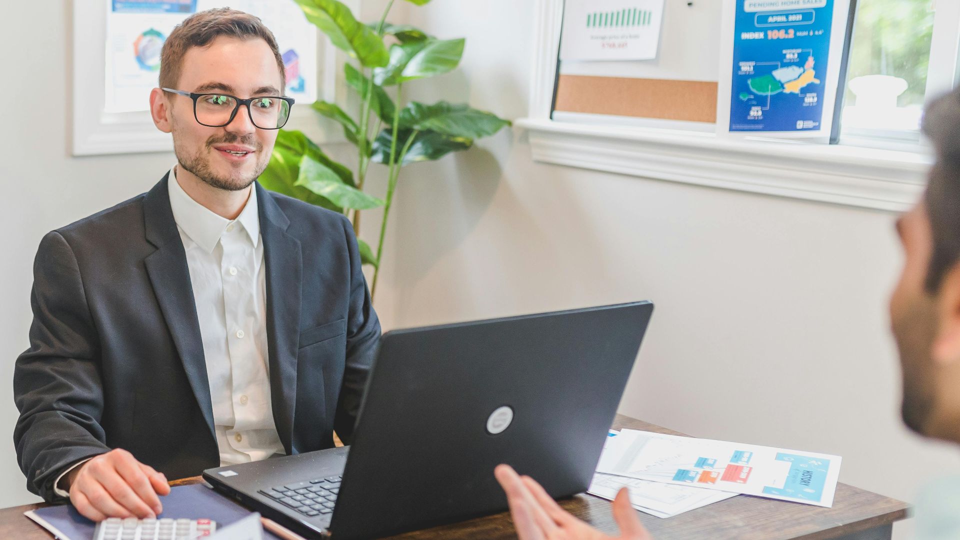 A mortgage broker and client discussing loan options in a modern office setting.