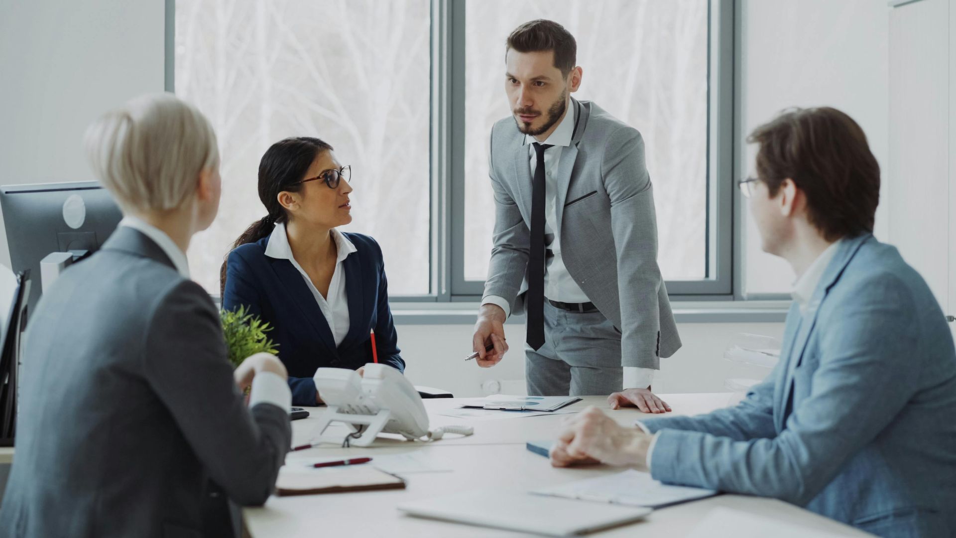 Professionals engaged in a serious business discussion in a bright office environment.