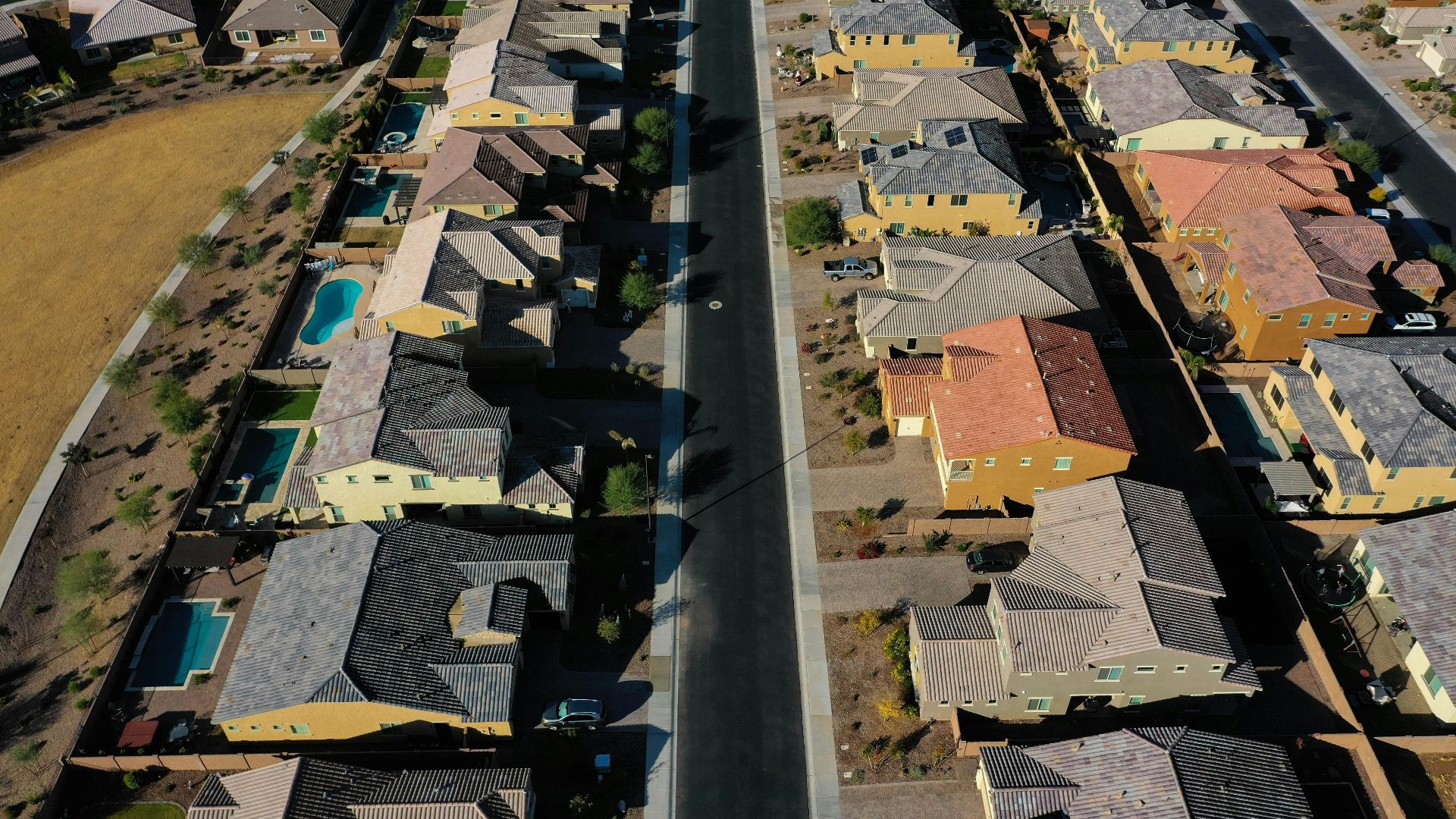 Aerial shot of a suburban residential area with neatly arranged houses and streets.