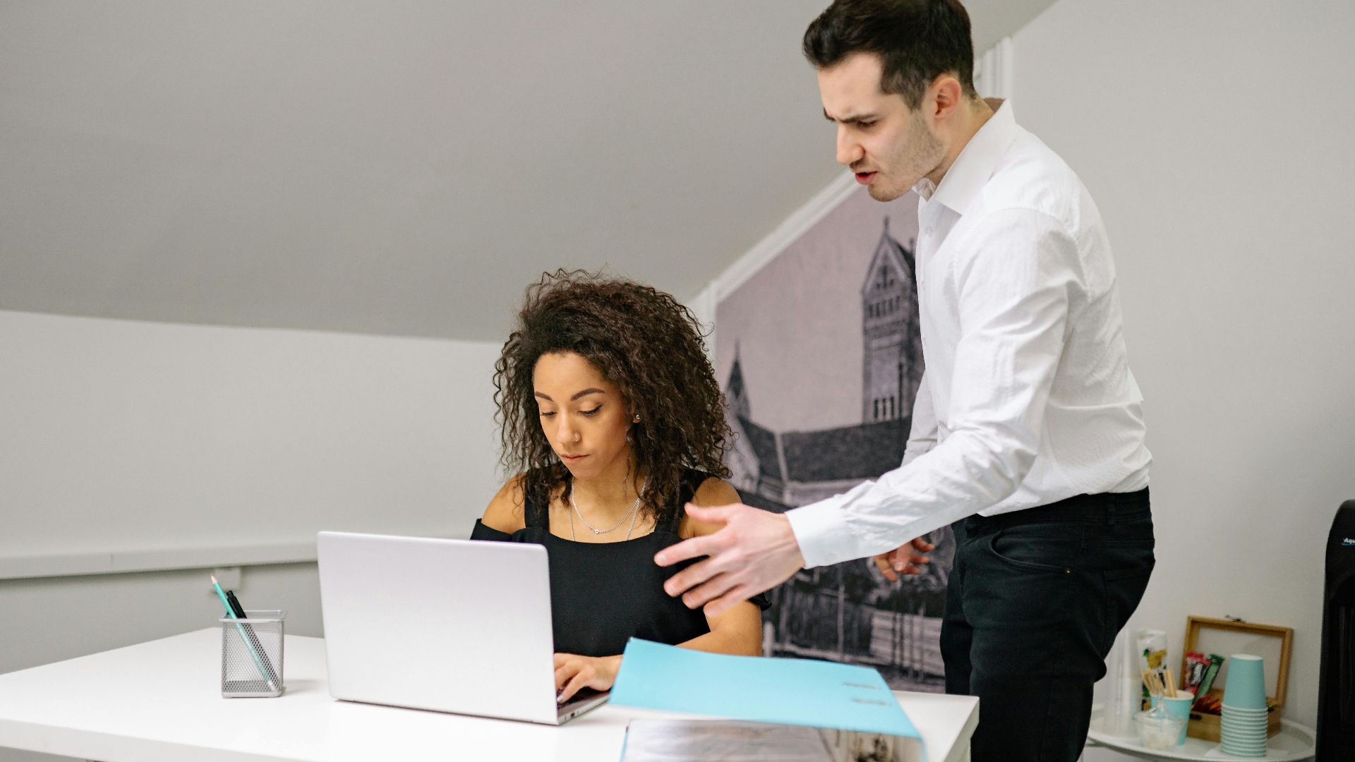 Manager and employee in discussion at the office, highlighting workplace dynamics.