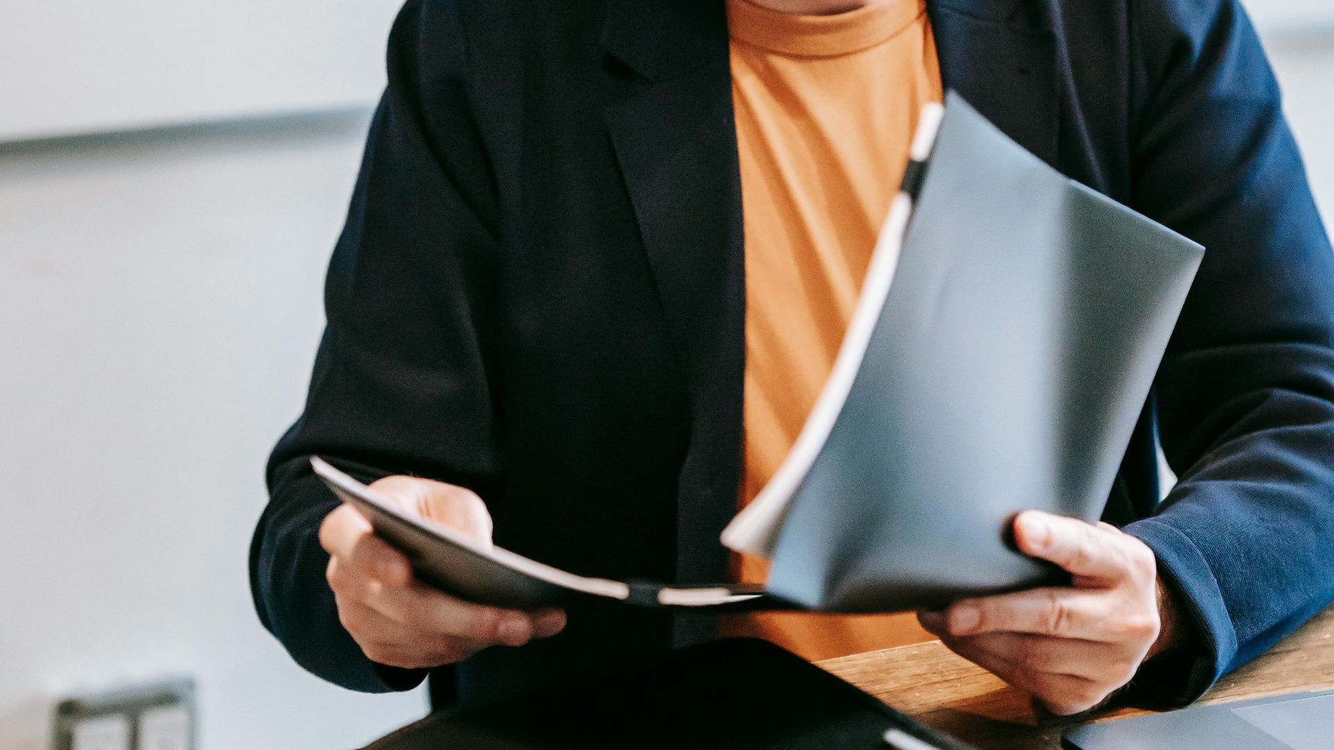 Businessman in a suit reviewing documents at an office desk, focused on work.