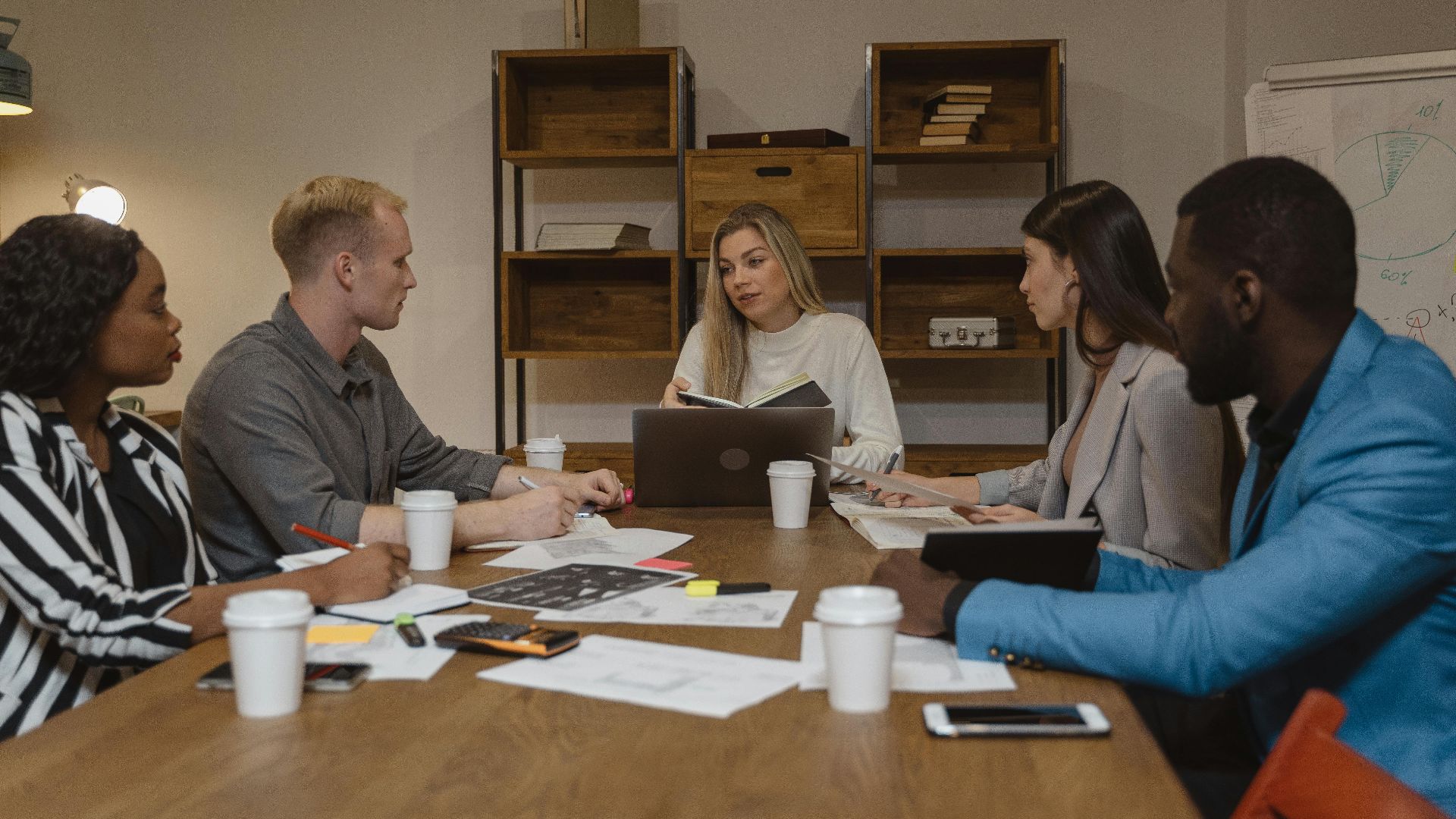 Business team discussing strategies in a modern office setting, focusing on collaboration.