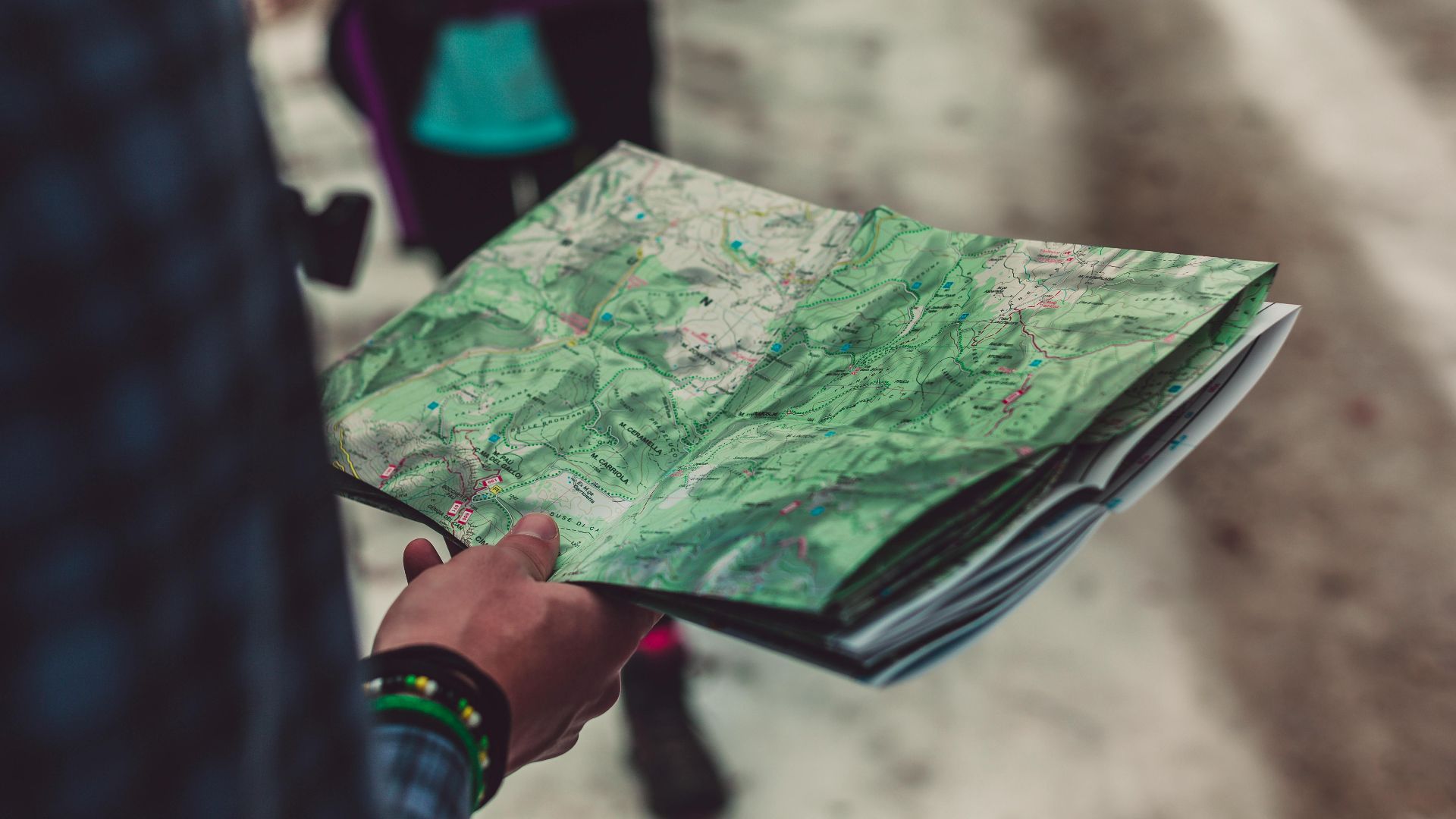 A close-up of a person holding a detailed route map outdoors, ideal for travel and exploration themes.