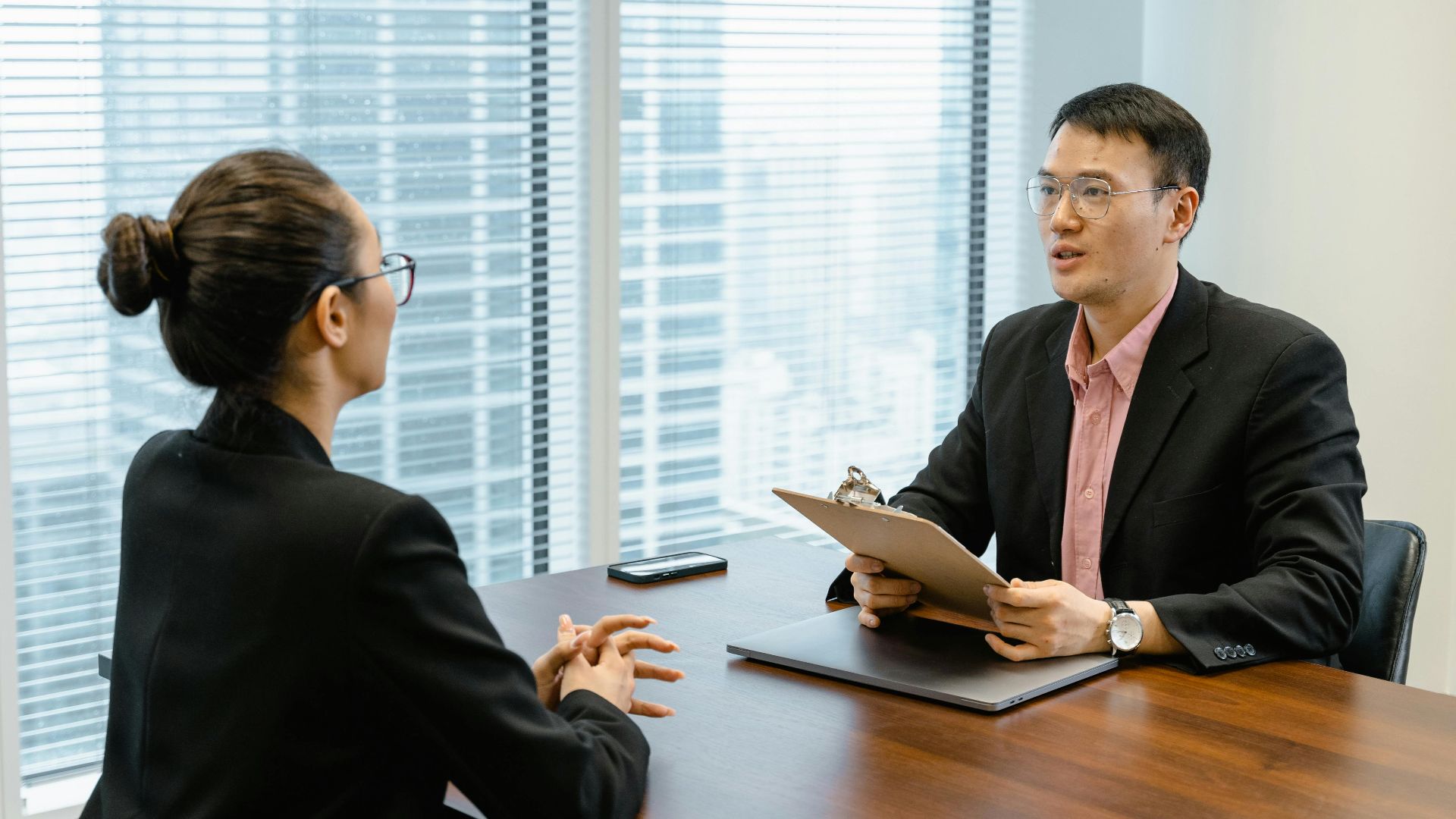 Professional business meeting in a modern office with two people discussing over documents.