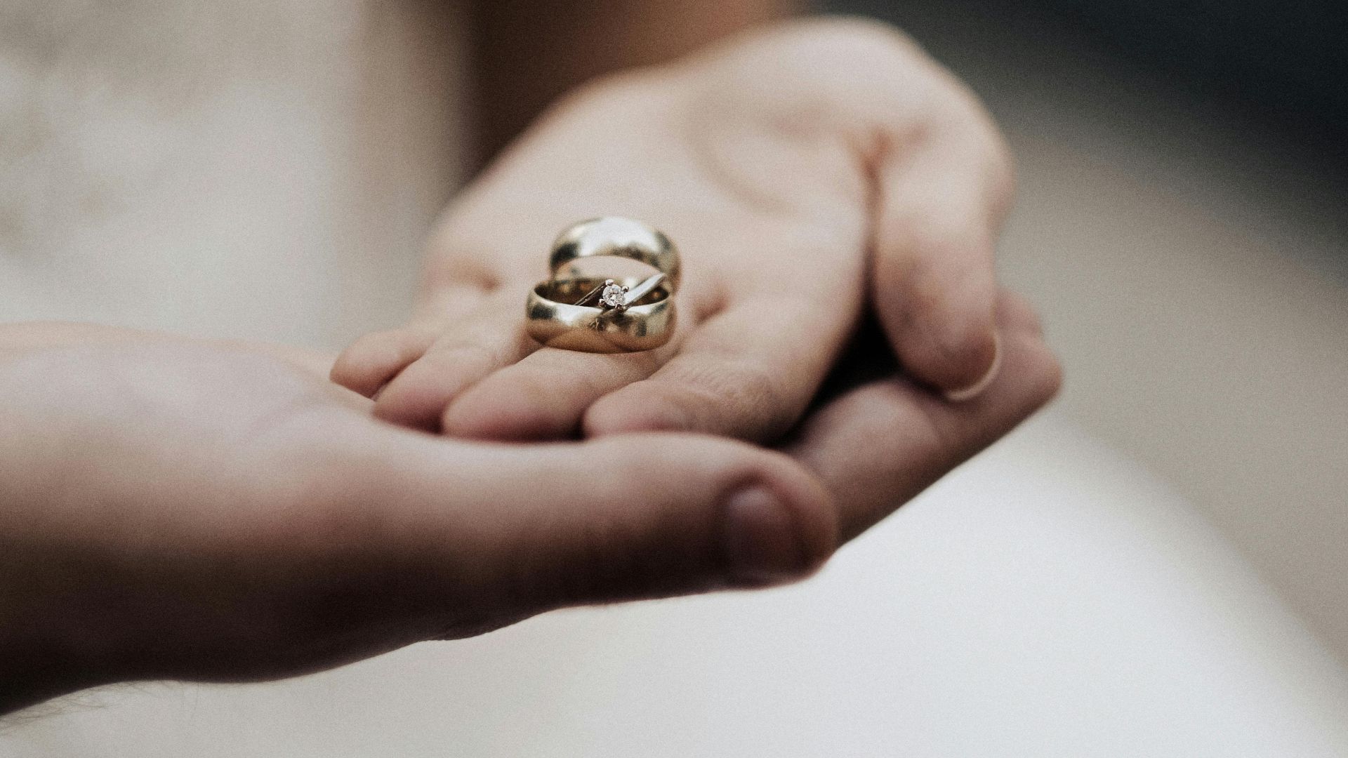 Bride holding wedding bands in a tender moment, symbolizing love and commitment.