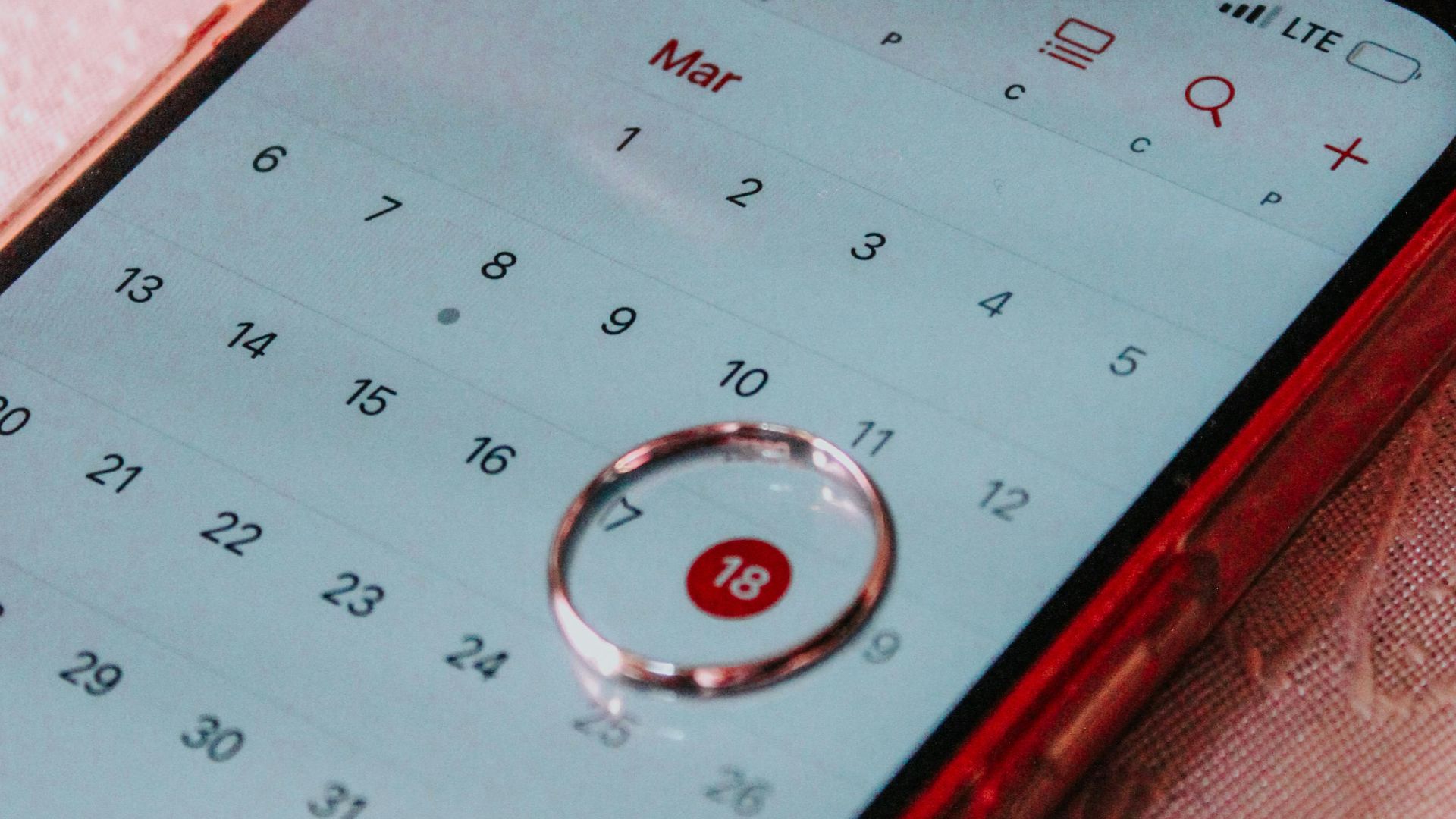A smartphone displaying a calendar with March 18th highlighted, signifying an important date.