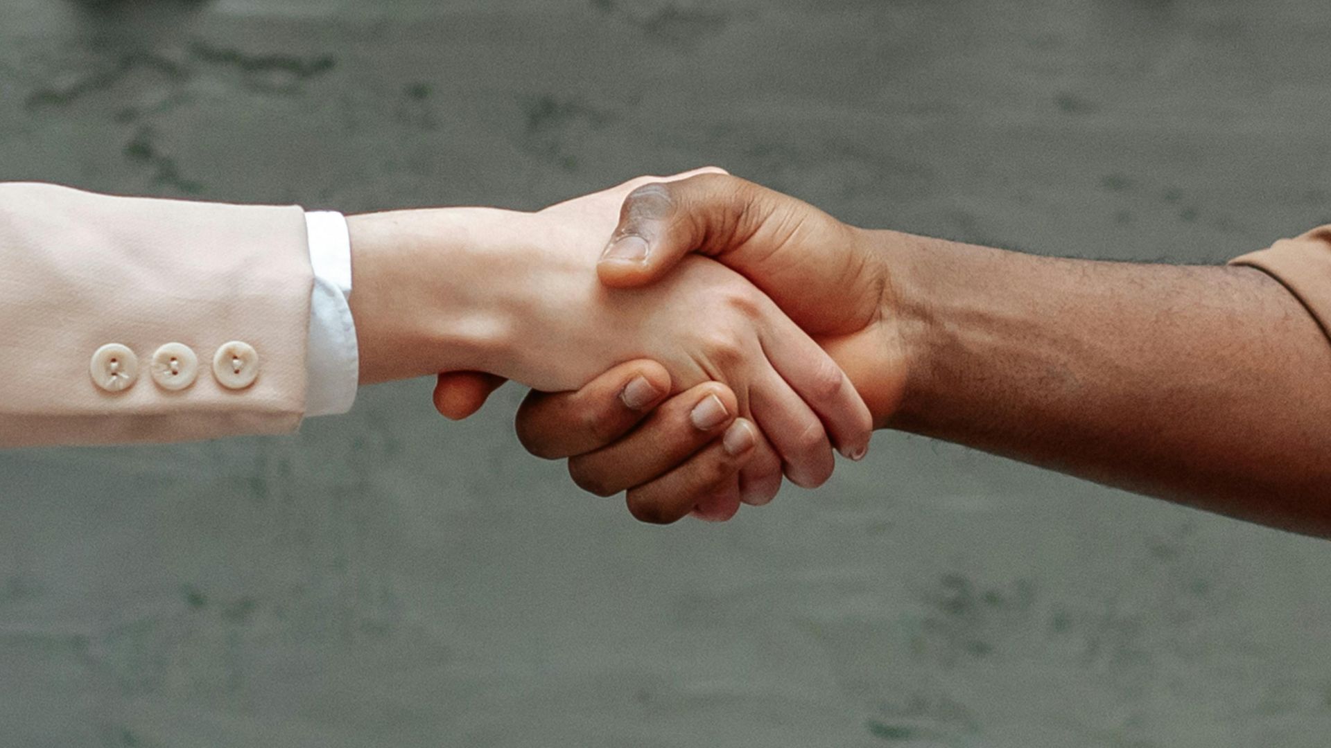Close-up of diverse hands shaking indoors, symbolizing partnership and agreement.