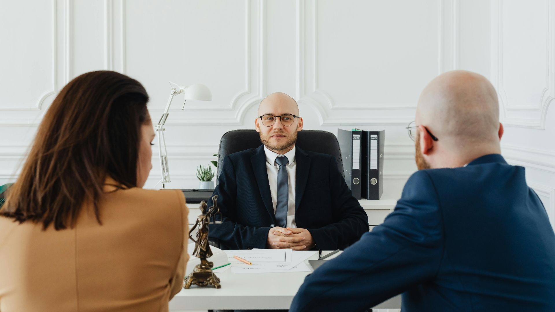 Lawyer meeting with clients in a formal office setting for legal consultation.