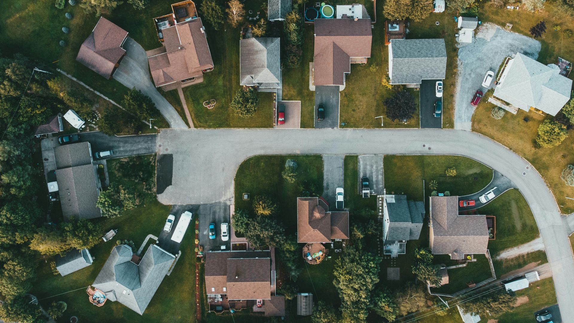 A top-down view of a suburban neighborhood showing houses, streets, and greenery.