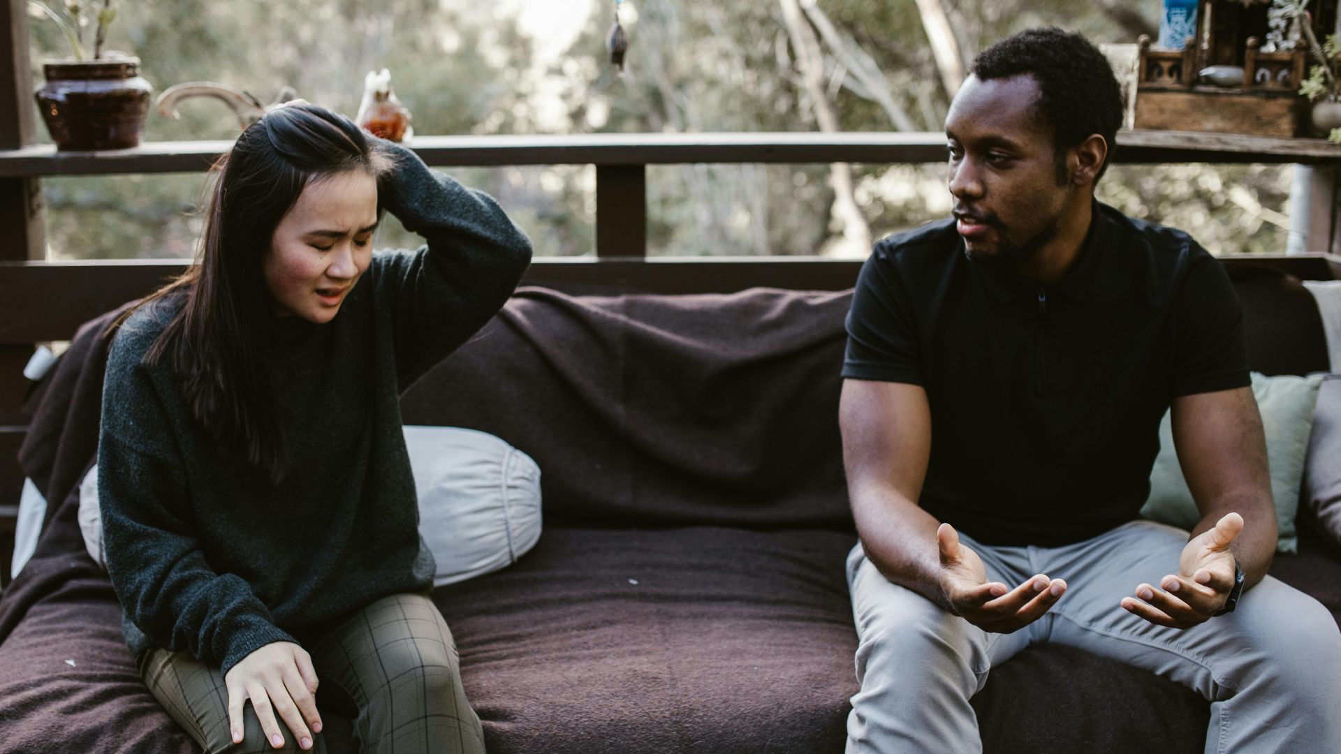 Couple having an intense discussion outdoors. Emotionally charged moment captured.