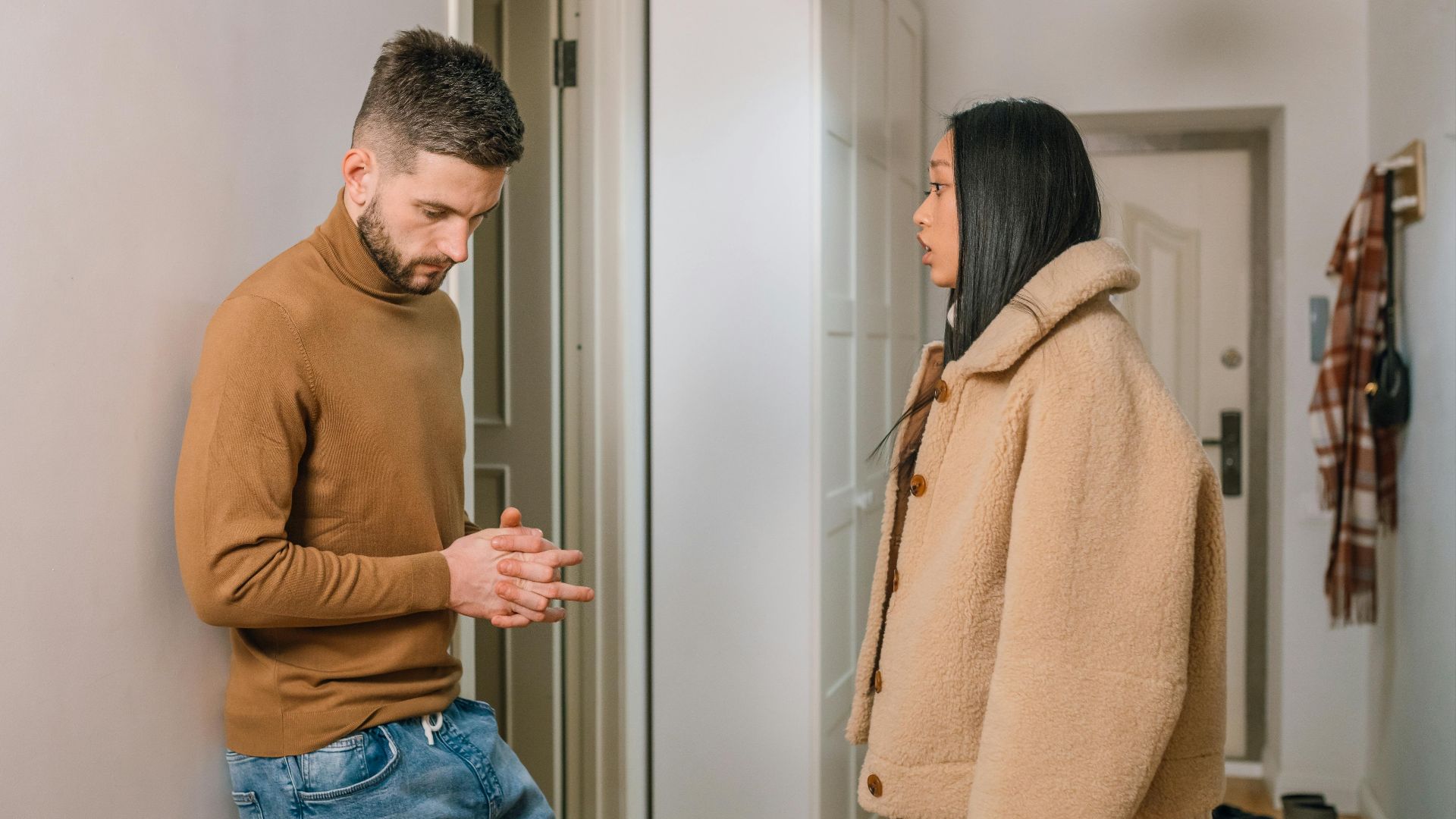 A man and woman having a serious discussion indoors, portraying relationship tension.