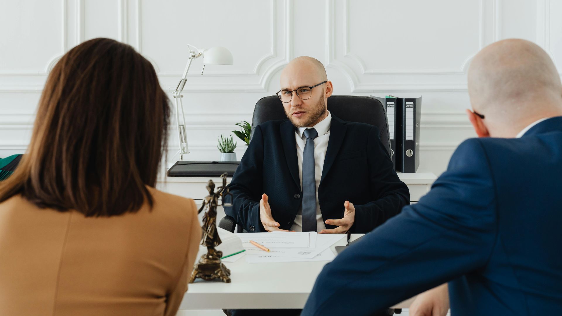 A professional business meeting with a lawyer and clients in a modern office setting.