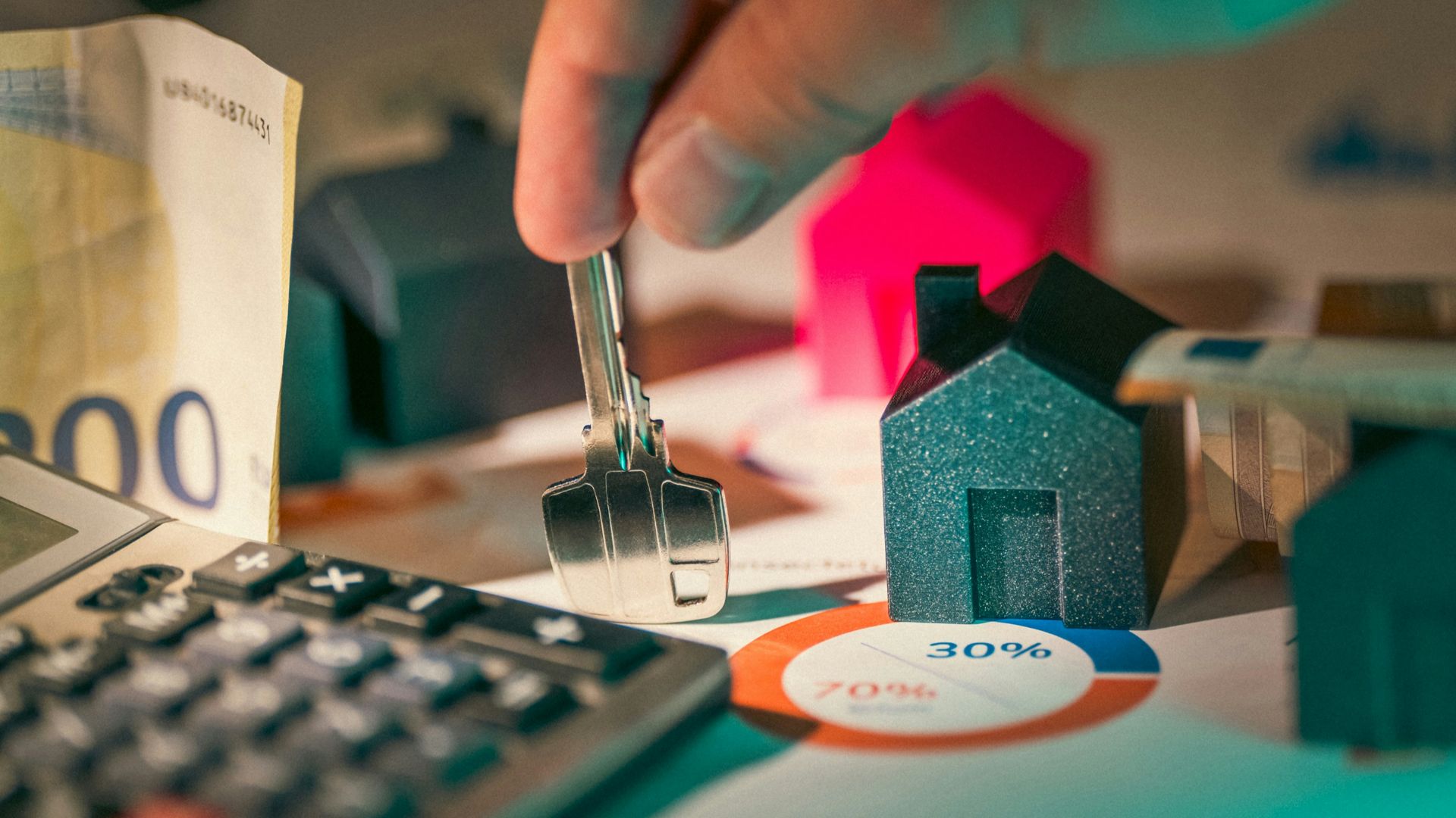 A person putting money into a calculator