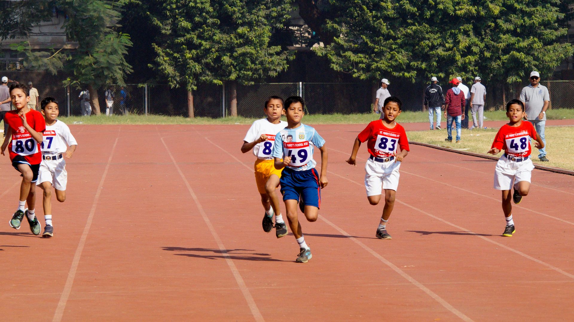 A group of young men running across a track