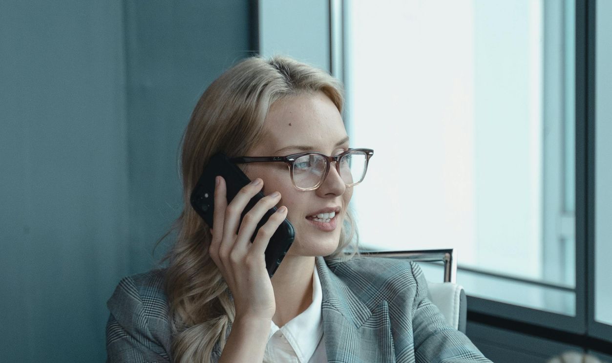 Woman in Gray Jacket Wearing Eyeglasses Sitting on Chair