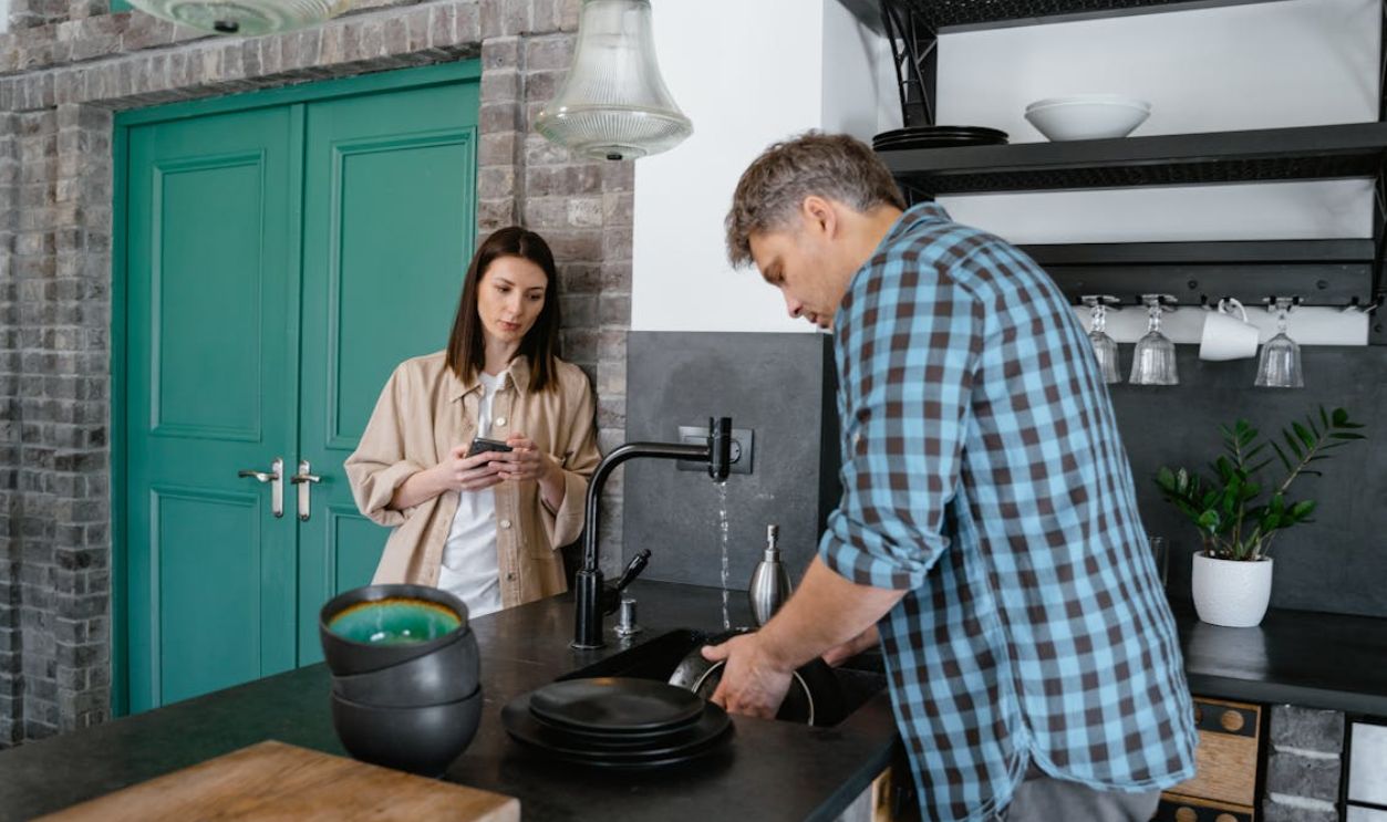Man cleaning the Dishes on Sink