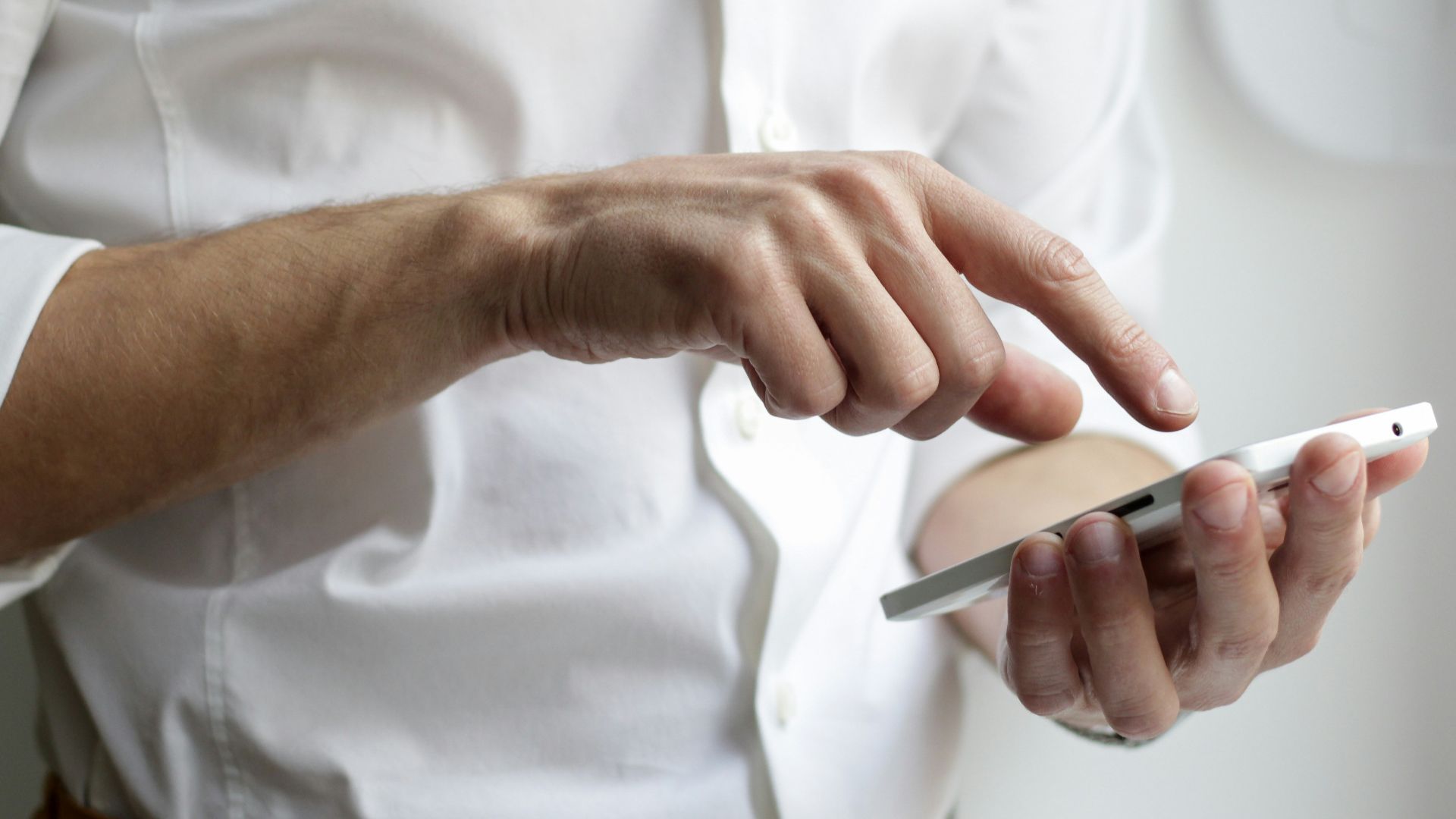 person holding white Android smartphone in white shirt